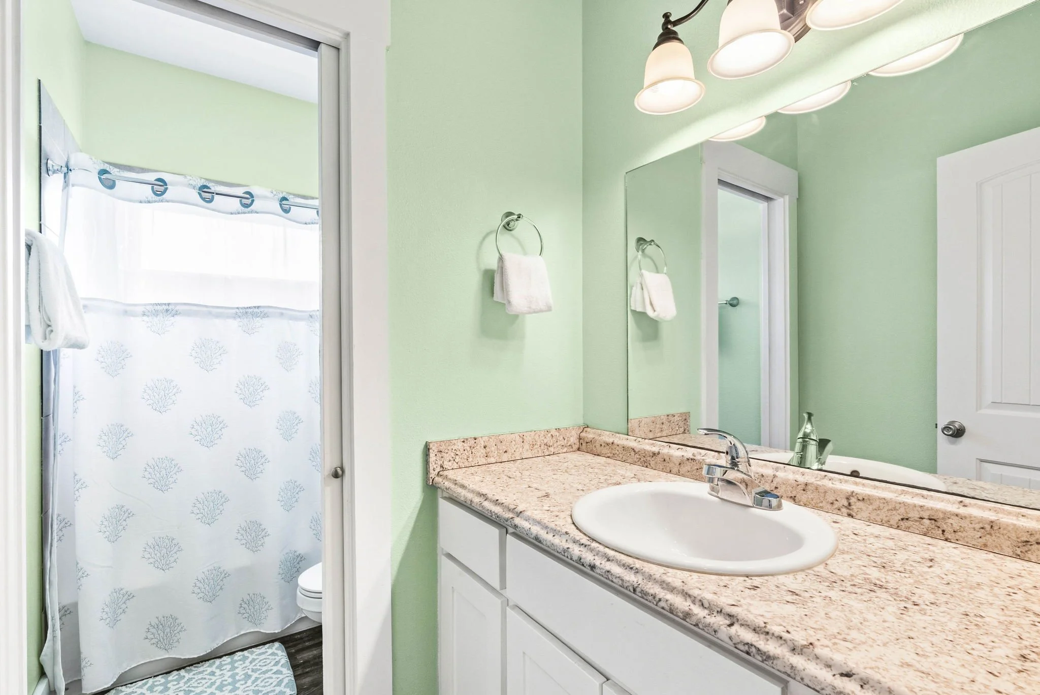 Bright bathroom with granite vanity and walk-in shower in Castaway Cottage, Holiday Beach vacation rental.