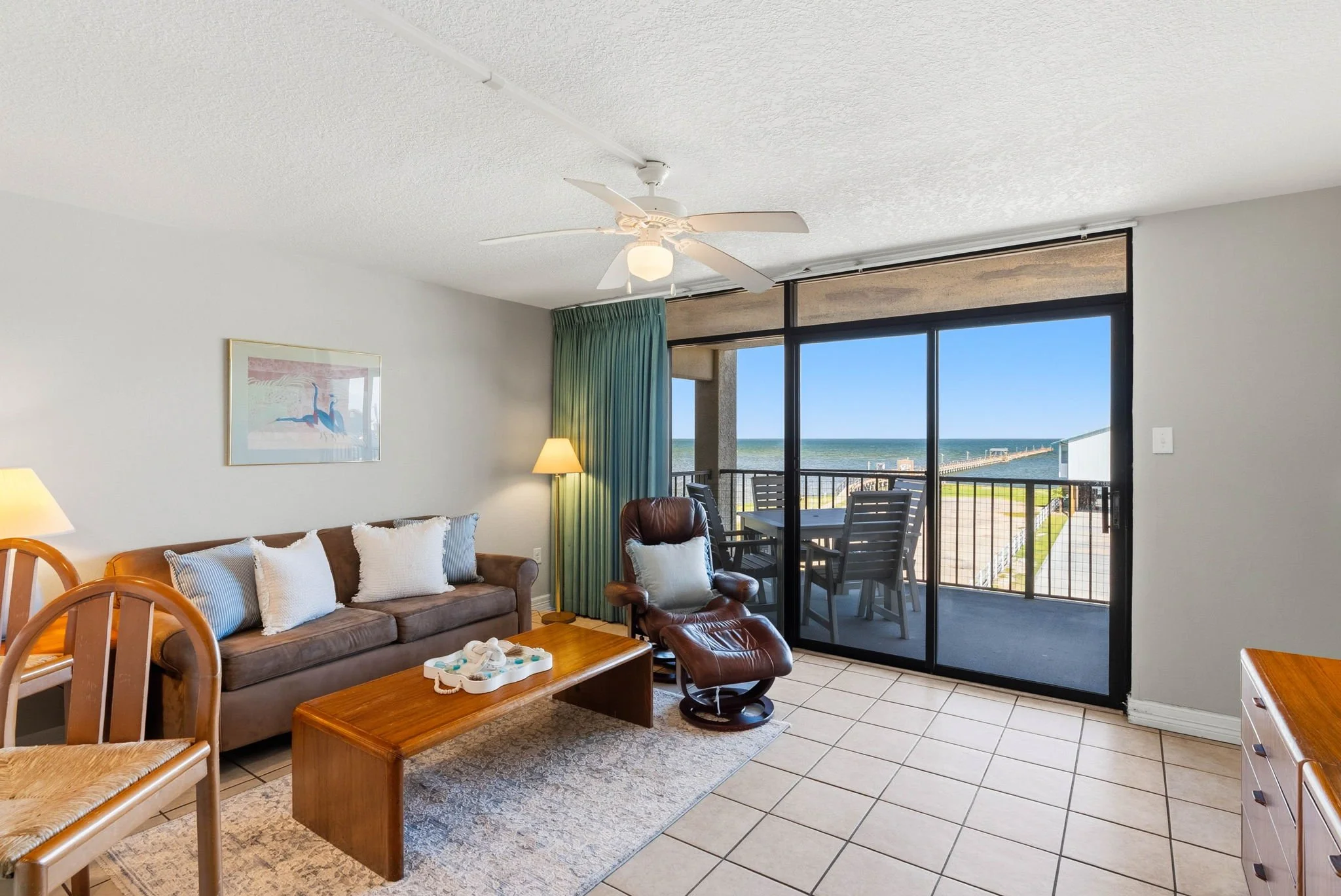 Open-concept living area with kitchen and bay views at Peaceful Pelican Laguna Reef