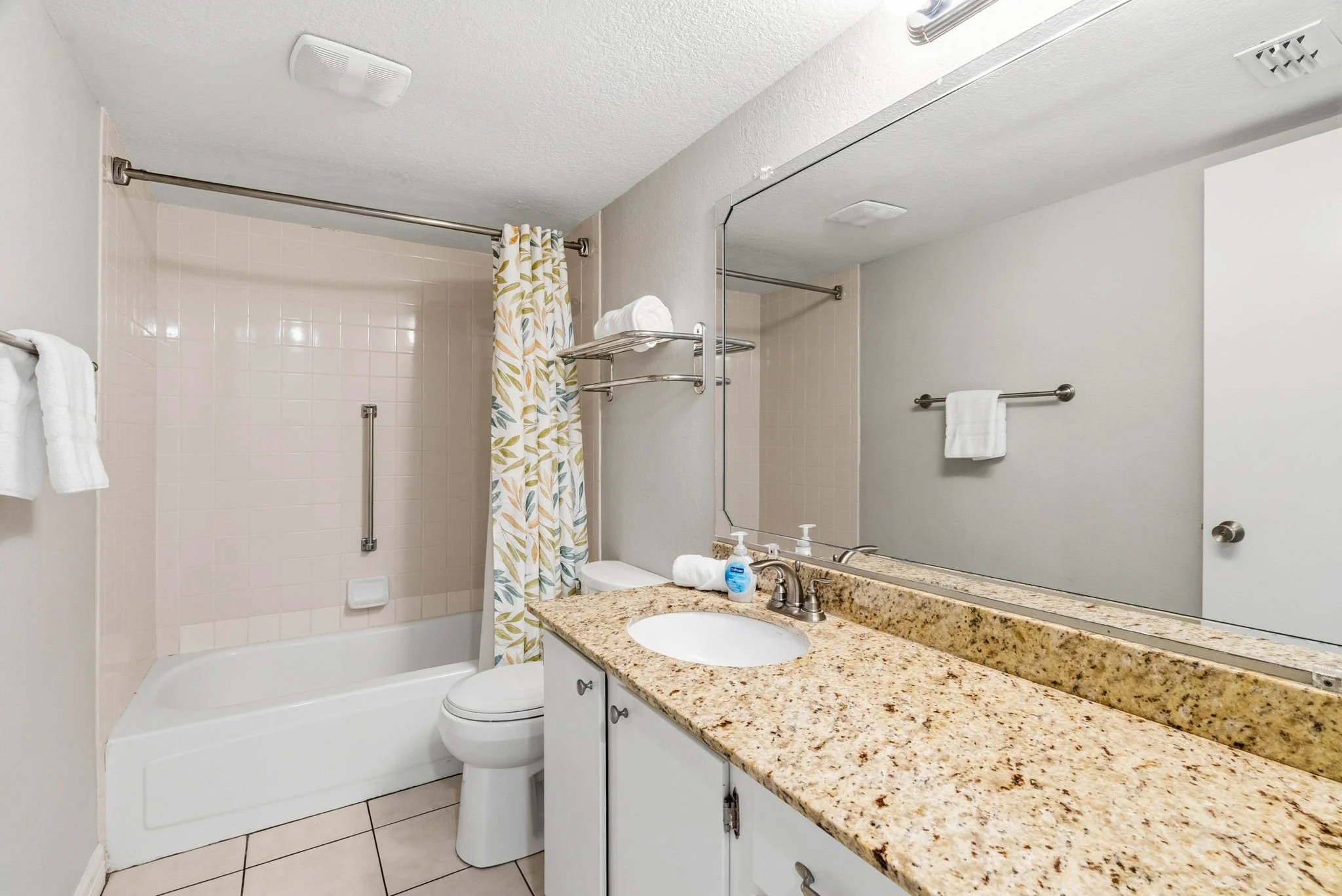 Guest bathroom with granite vanity and tub shower in Peaceful Pelican, Rockport TX vacation rental