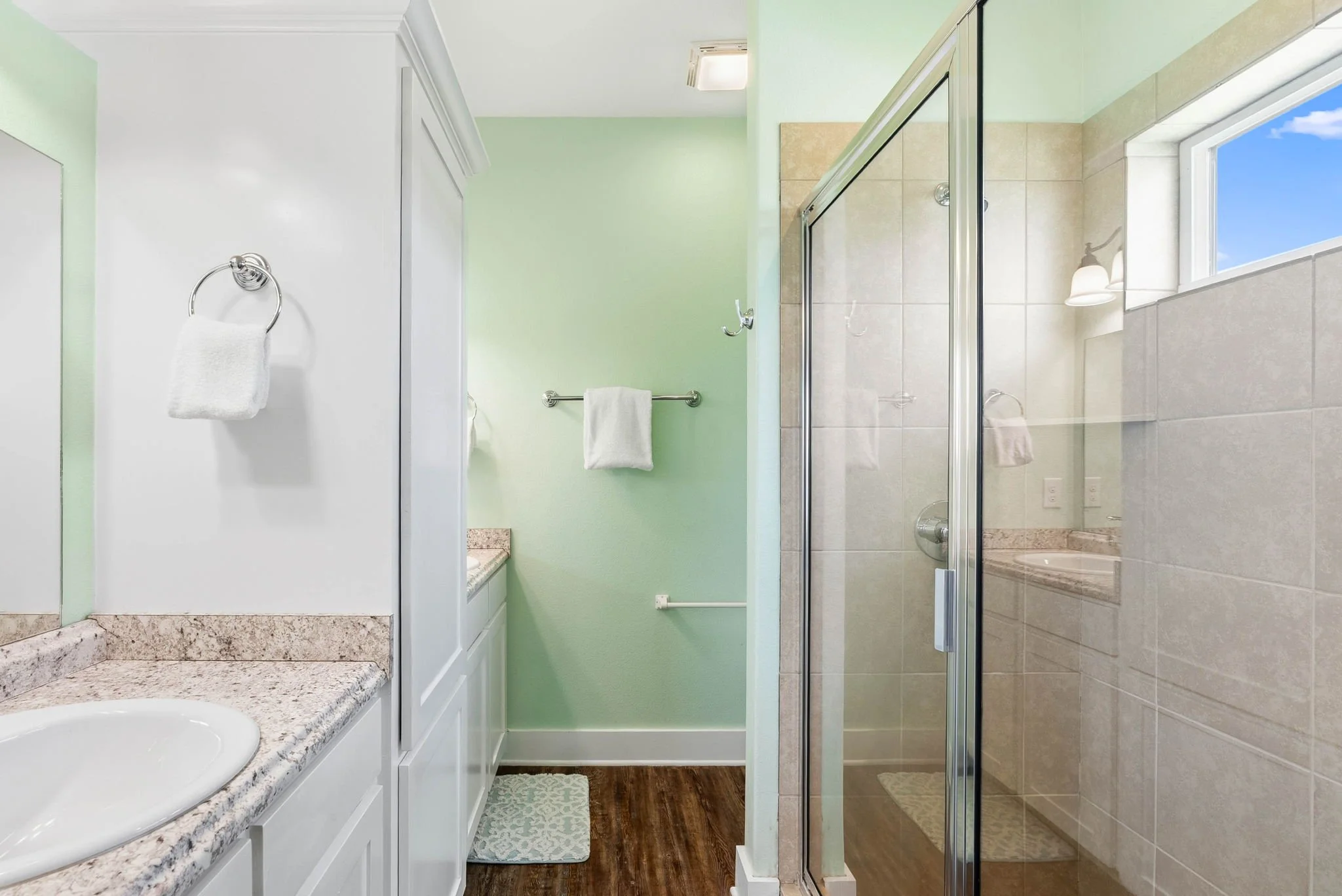 Spacious bathroom with walk-in glass shower at Castaway Cottage canalfront vacation rental near Rockport TX.