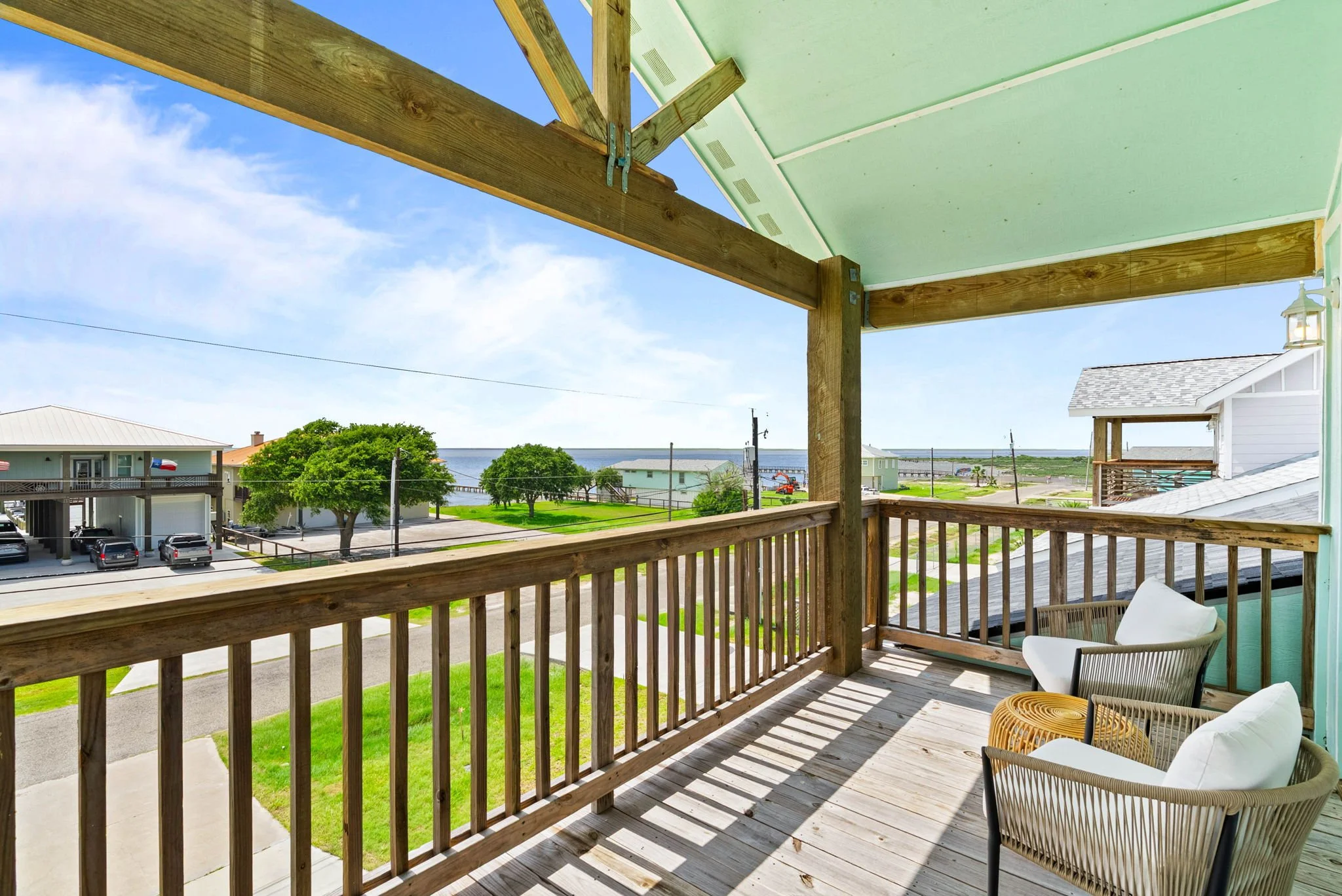 Furnished upper balcony with neighborhood and bay views at a Rockport coastal home