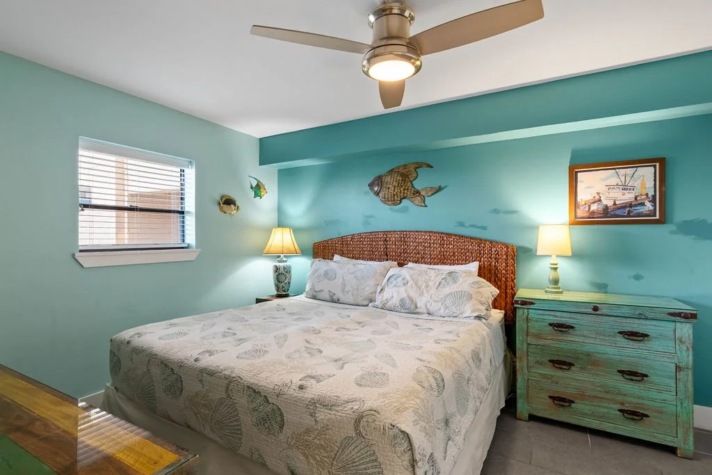 Tranquil king bedroom with tropical decor and woven headboard at Beauty Blues, a Rockport TX waterfront rental.