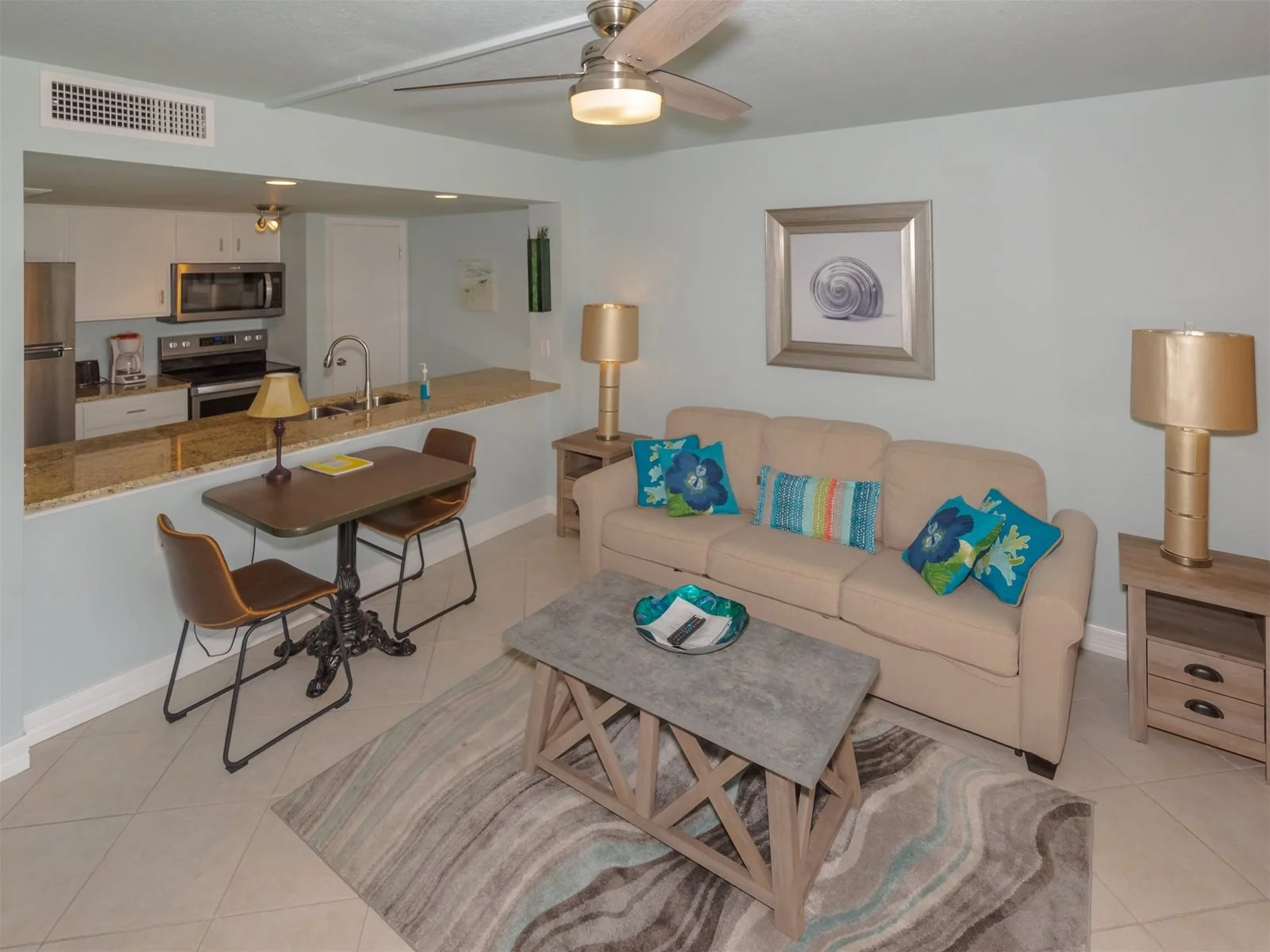 Living room with queen sleeper sofa and bay view windows – Tradewinds condo Rockport