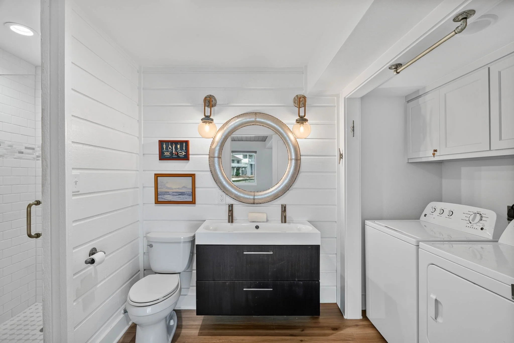Downstairs full bath with shiplap walls, modern vanity and laundry area in Rockport TX vacation rental 