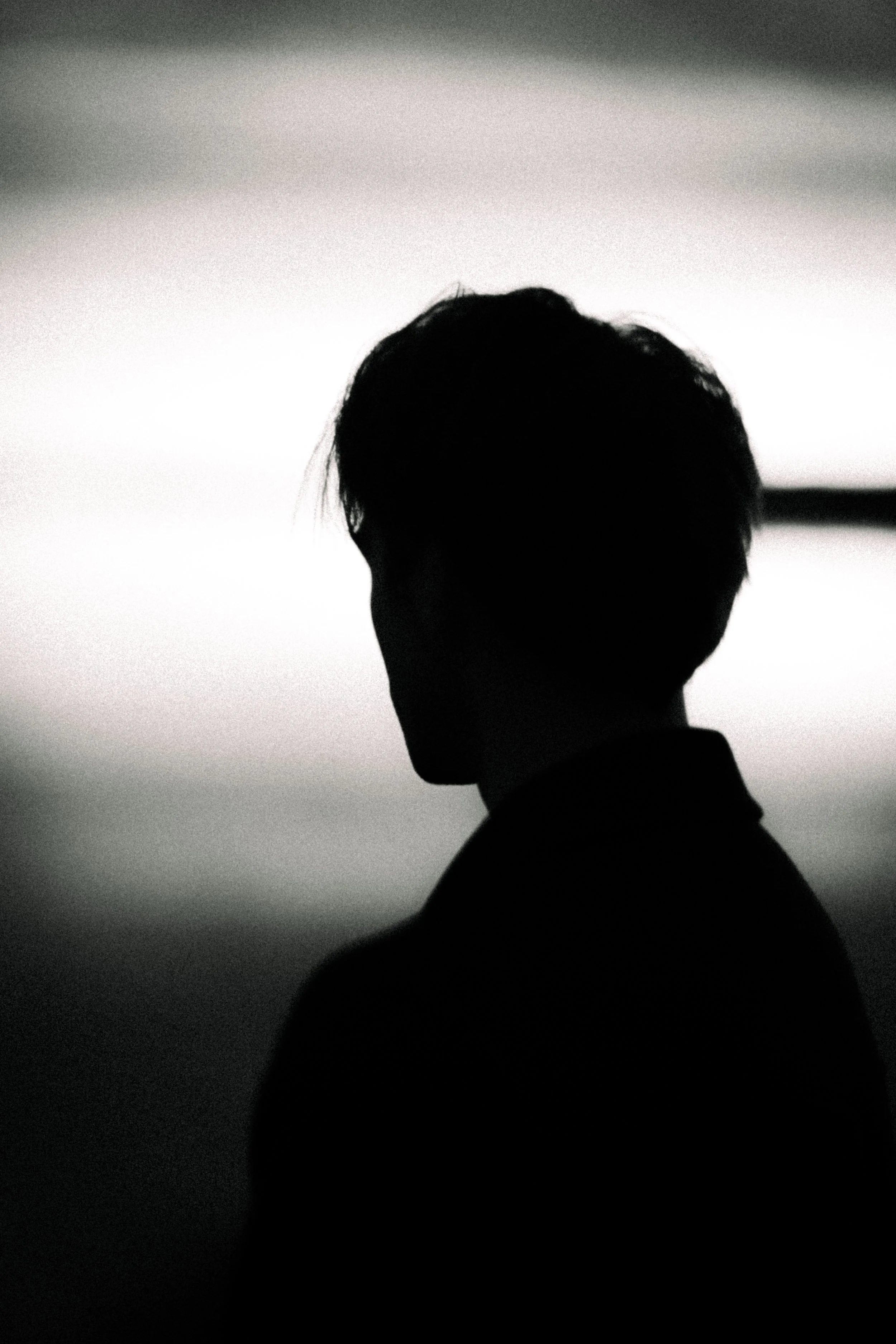 Silhouette of a person's profile against a white and gray gradient background