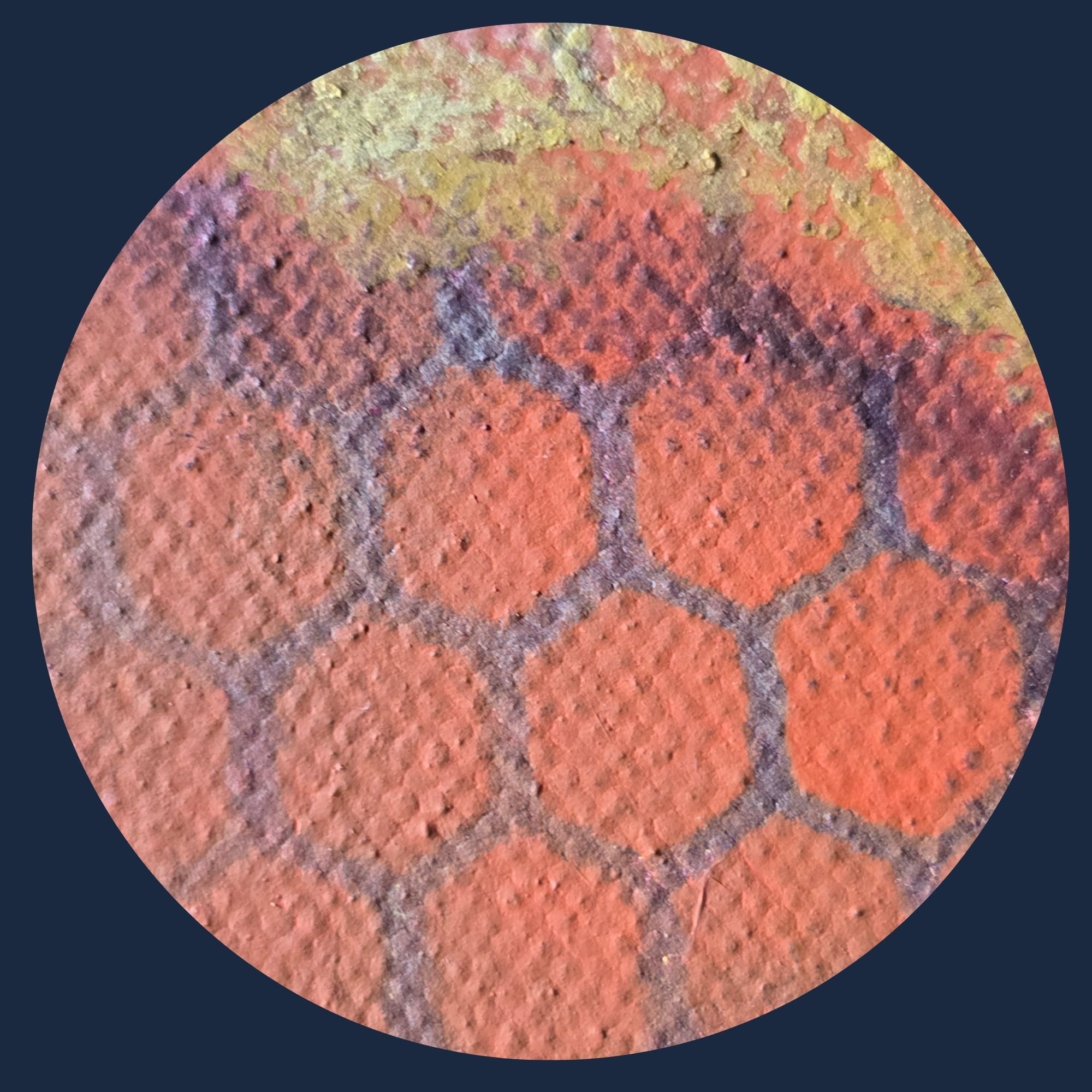 Close-up of a rusted, textured metal surface in reddish-brown and yellow hues.