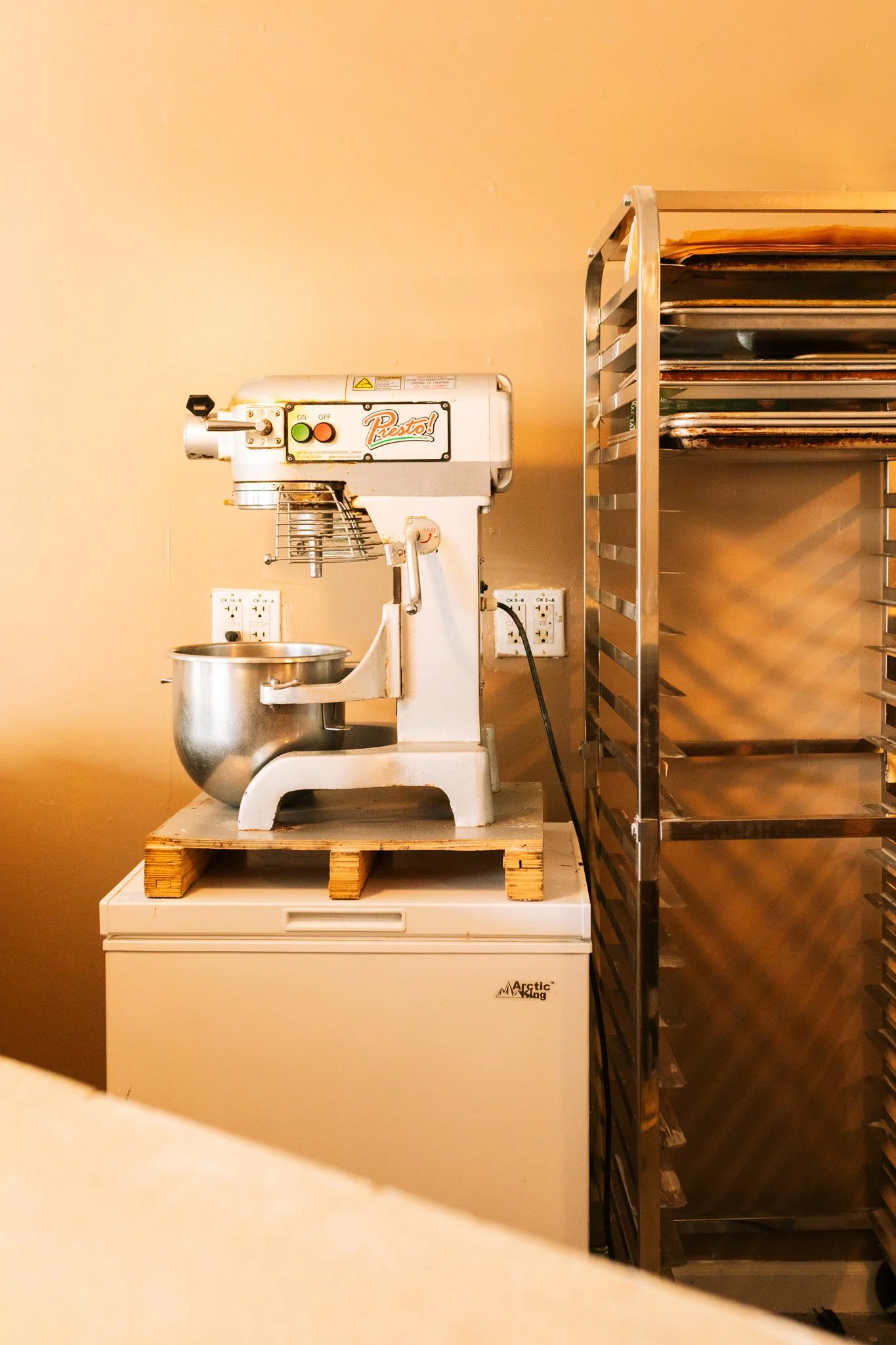 white bakery mixer on refrigerator near backing racks