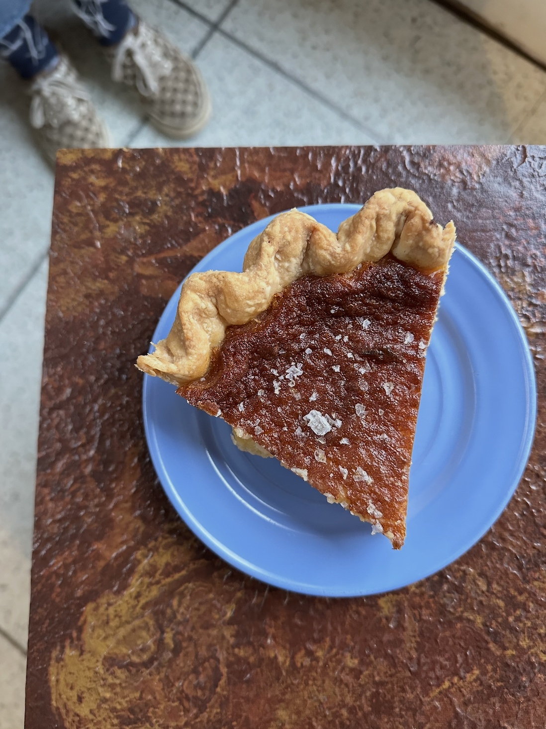 slice of pie on a bright blue plate sitting on counter