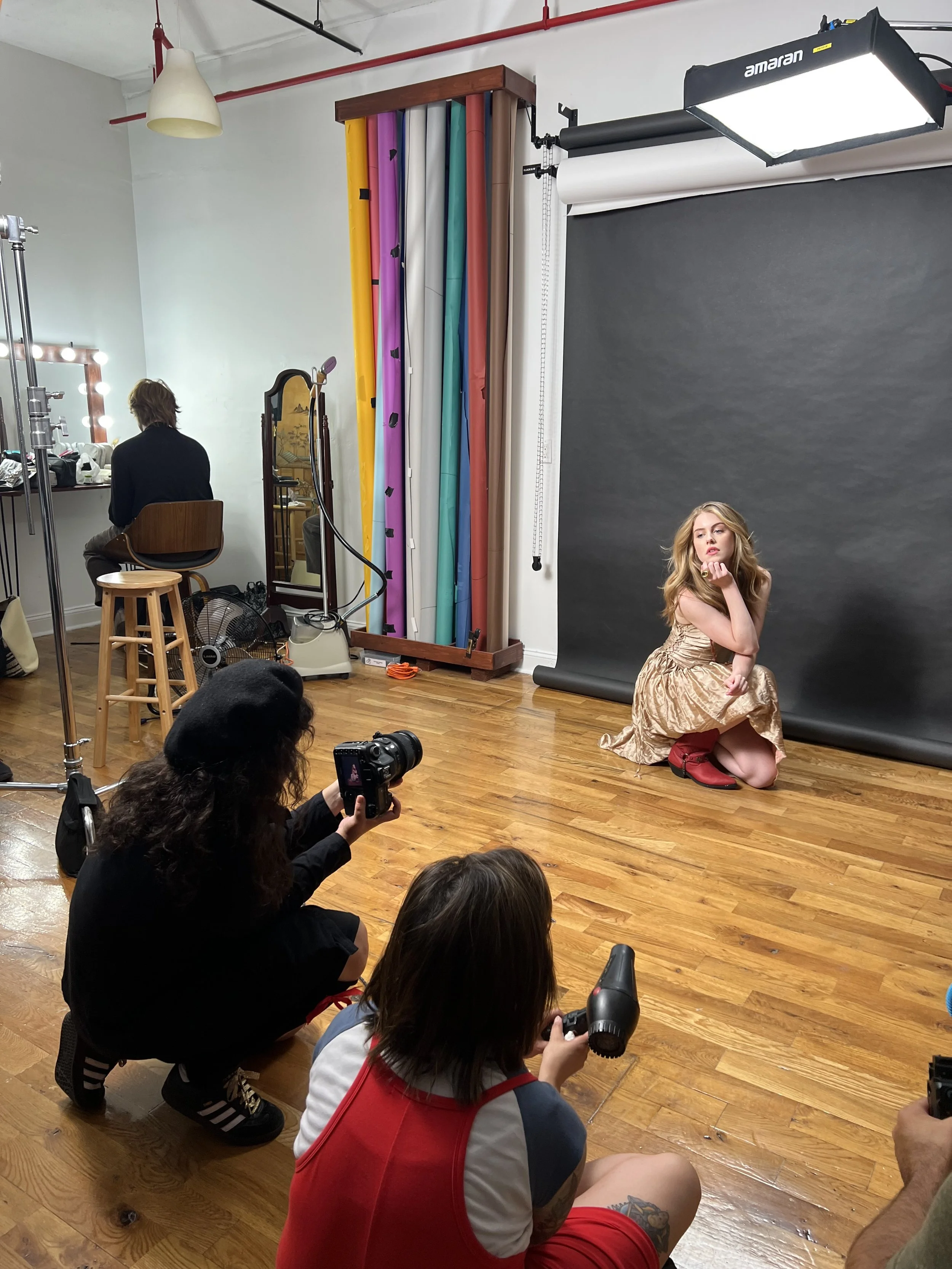  Lindita takes stills of Michelle for a fictional fashion magazine to promote Teen Sasquatch. Brianne Costa fans Michelle with a blowdryer. 