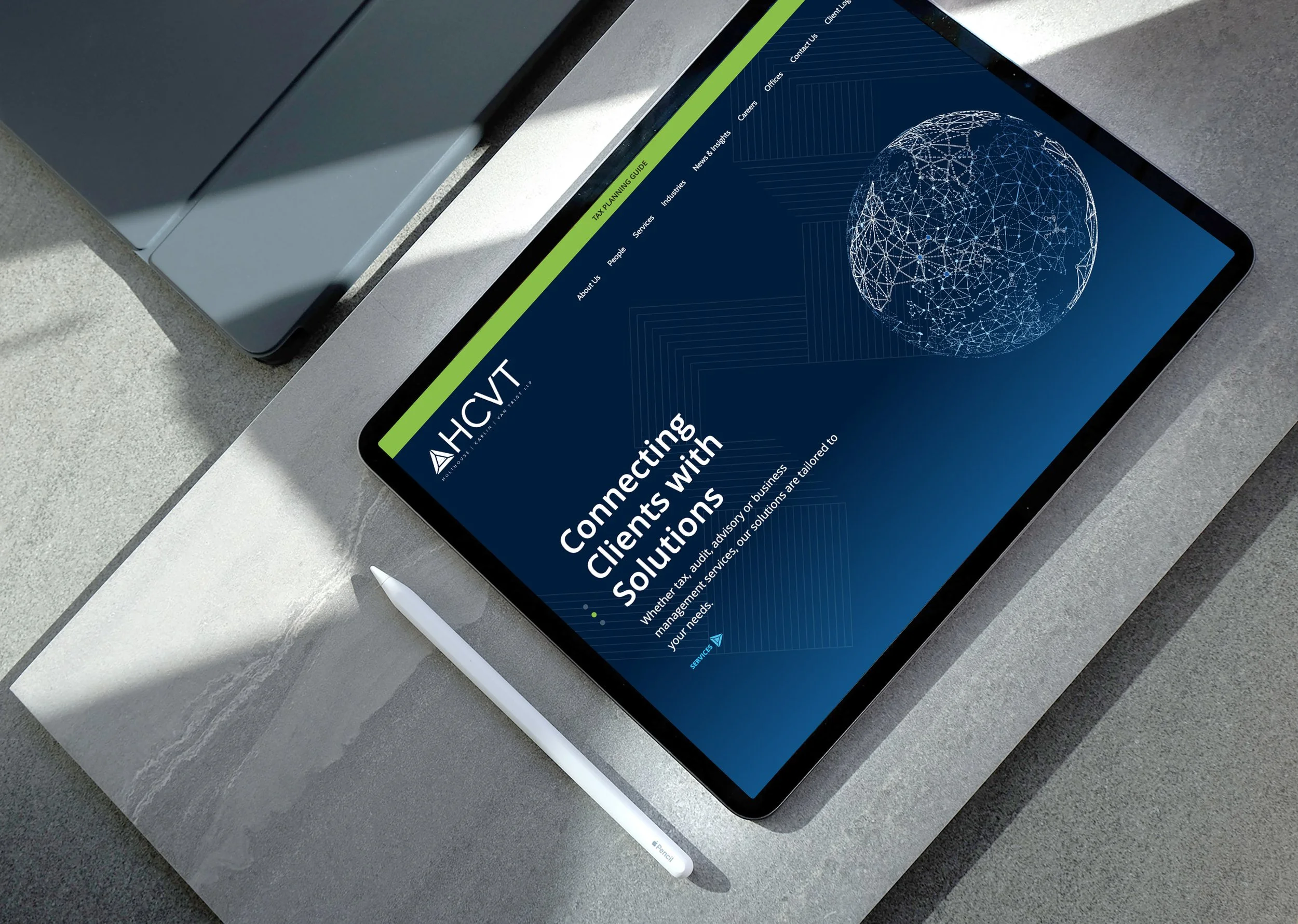 Tablet displaying HCVT accounting firm website homepage with a dark blue, data-inspired design, shown on a desk with stylus.