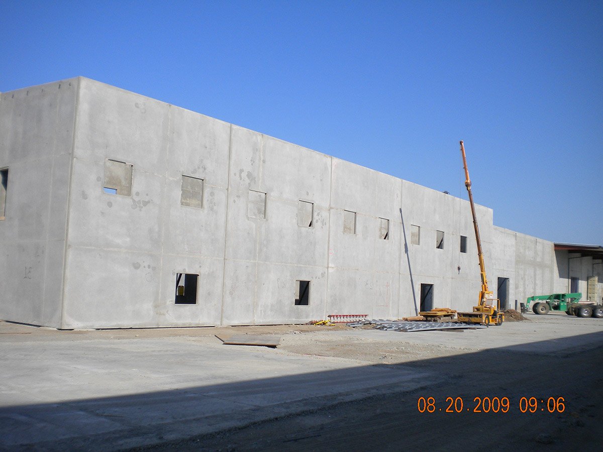 Exterior view of Crain Walnut facility construction from another angle with a crane at work
