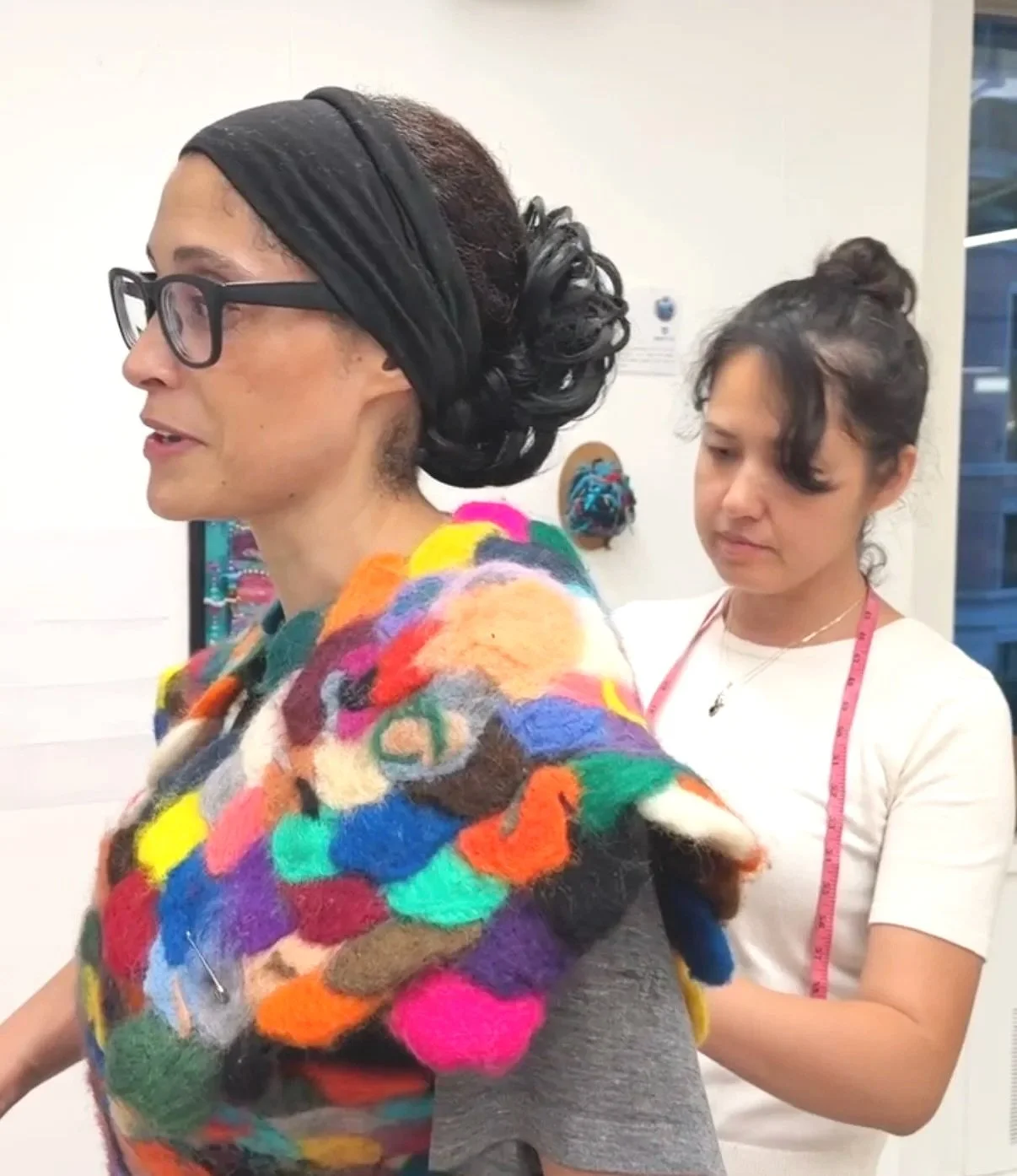 Model Adrienne Fitting her outfit made by Designer Brandy Godsil, who is in the backgroun working on the piece while Adrienne wears it