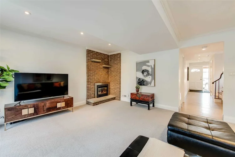 Finished lower level with a brick fireplace and TV wall, North Central Toronto, by First Place Homes
