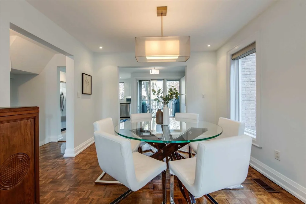 North Central Toronto dining room renovation by First Place Homes: glass table, wood floors and a drum pendant