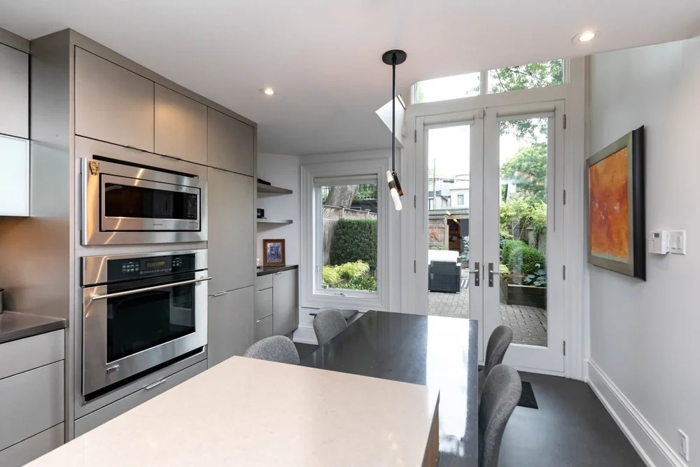 Victorian home kitchen in Toronto by First Place Homes: wall ovens beside French doors to the garden