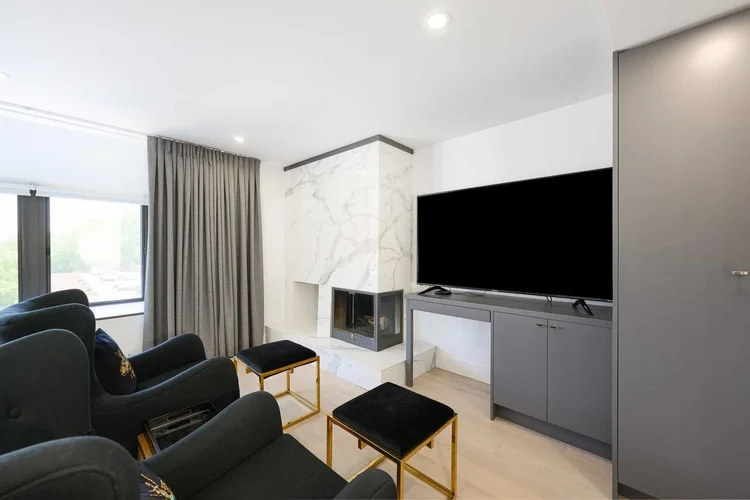 Toronto townhome media room by First Place Homes: marble fireplace wall, wall-mounted TV and grey drapery