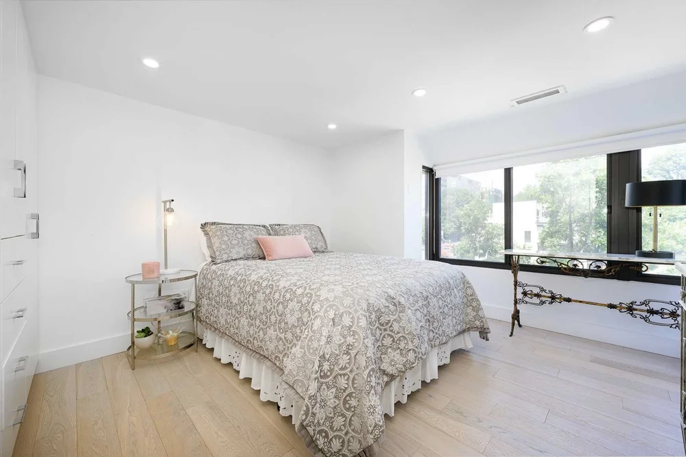 Toronto townhome bedroom renovation by First Place Homes: pale wood floor and corner windows