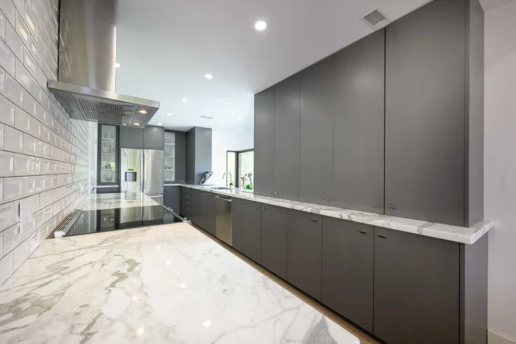 Toronto townhome kitchen renovation by First Place Homes: dark cabinets, marble counters and white subway tile