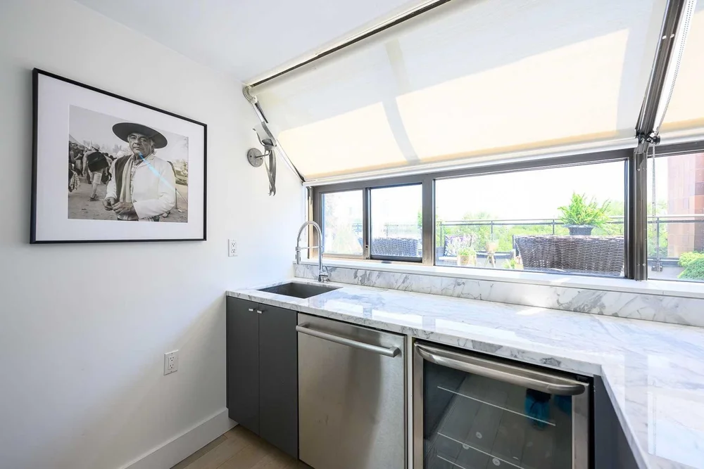 Toronto townhome kitchen by First Place Homes: bar counter under sloped skylight windows with a wine fridge
