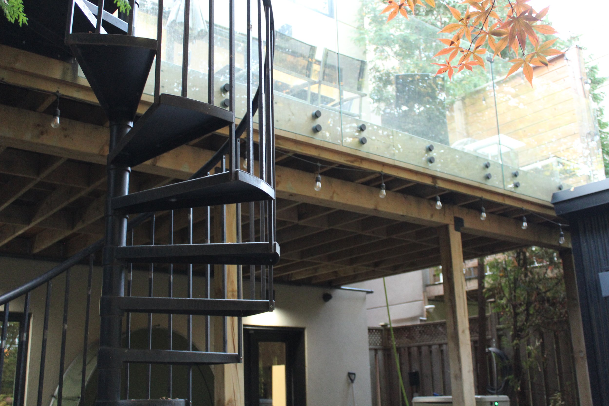 A second storey large rear yard deck facing east allowing for early morning coffee and sun on those warm spring and fall days. A gas-line for an outdoor bbq, string lights, trees, and a glass railing provide a seamless view to a park like setting