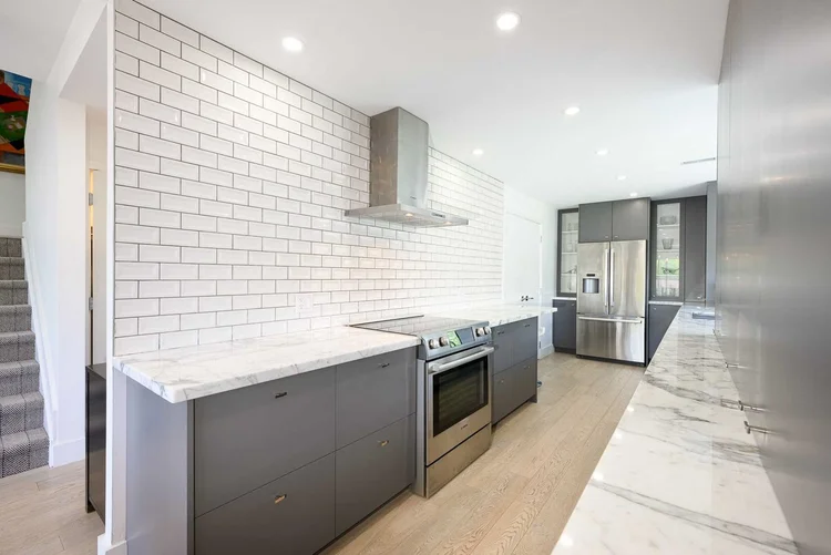 Toronto townhome kitchen renovation by First Place Homes: subway tile galley with marble counters
