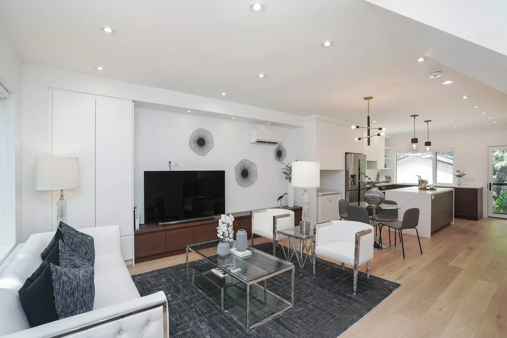 High Park home renovation by First Place Homes: living room open to the kitchen with a walnut island