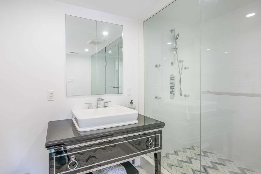 Toronto townhome bathroom by First Place Homes: vessel sink on a mirrored vanity beside the shower