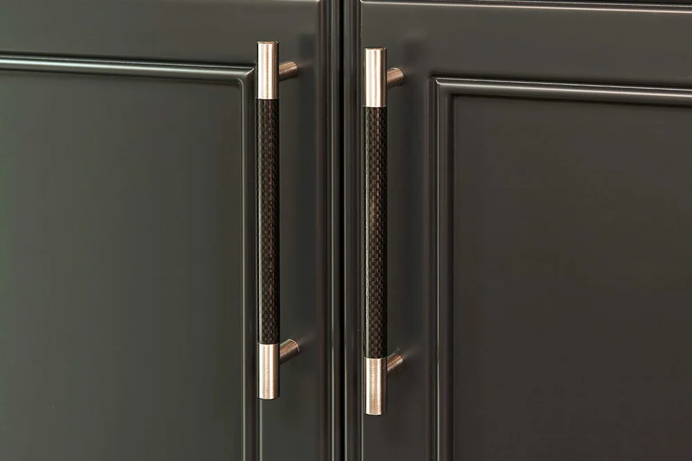 Cabinet door detail from a Toronto home addition by First Place Homes: dark green cabinetry with brass pulls