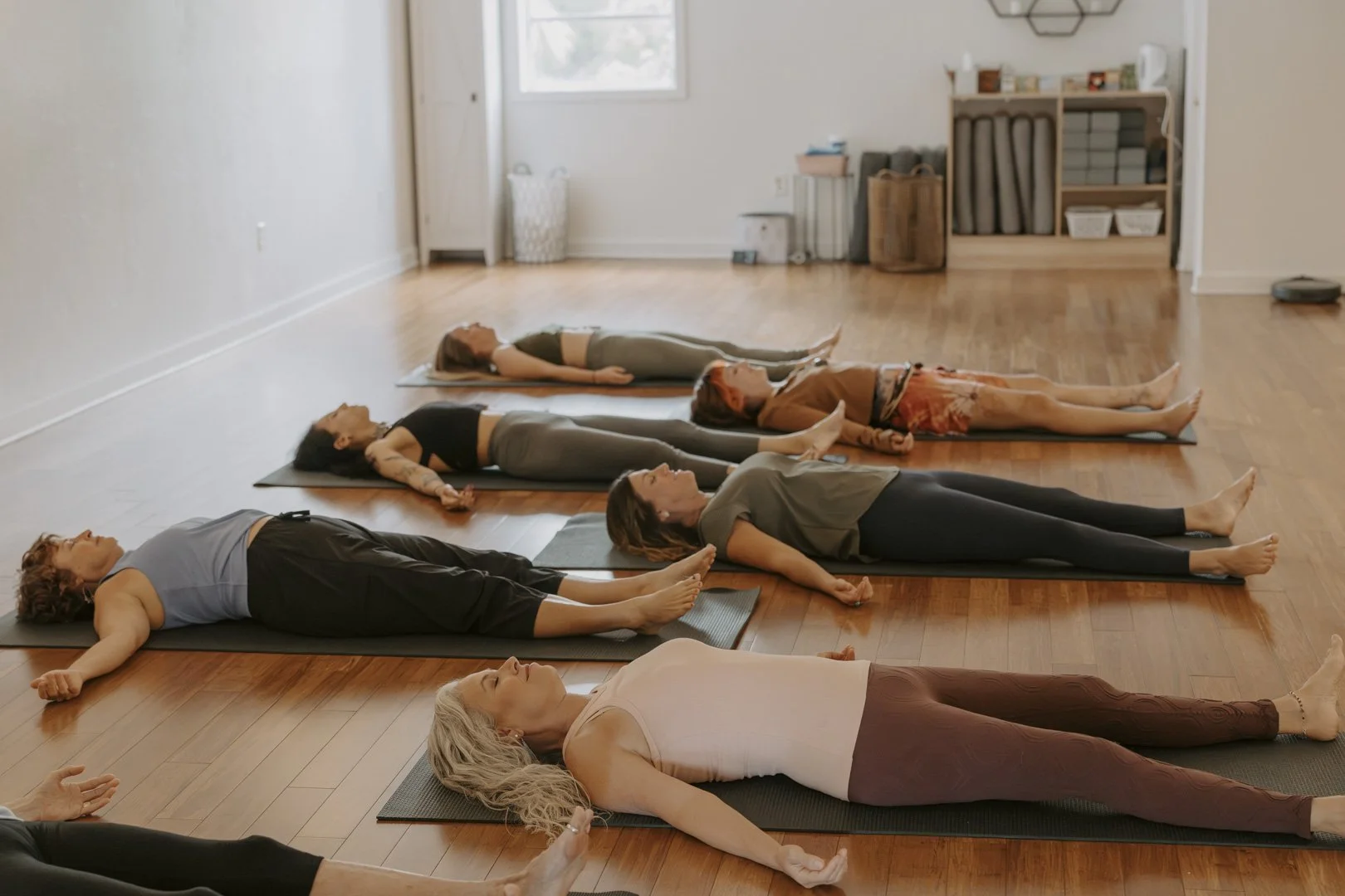 People participating in a yoga class lying on mats in a the Ritual Space Yoga Studio