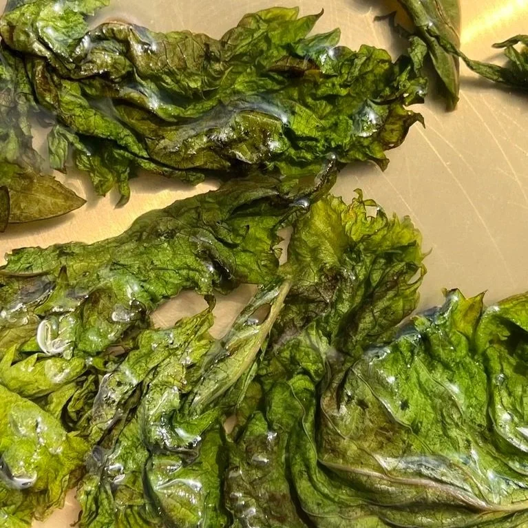 wilted shiso leaves in a simple syrup in a pot
