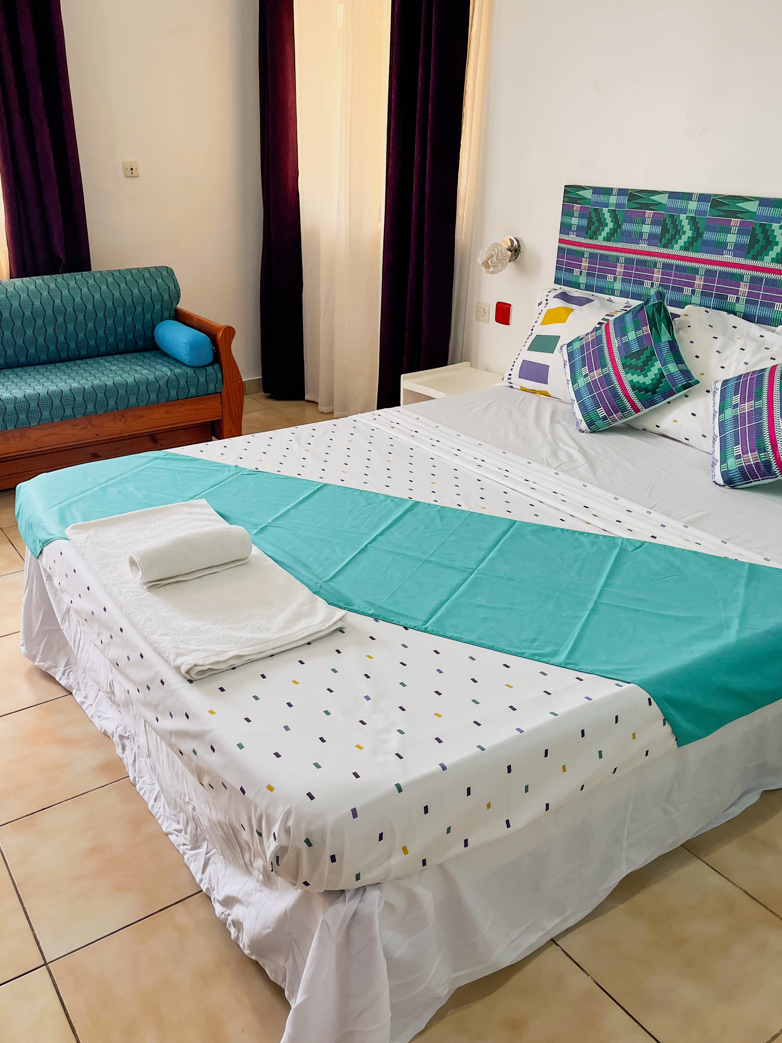 A guest room at Residence Sahoty in Grand Popo, Benin is decorated in turquoises, purple and white African fabrics. (Copy)