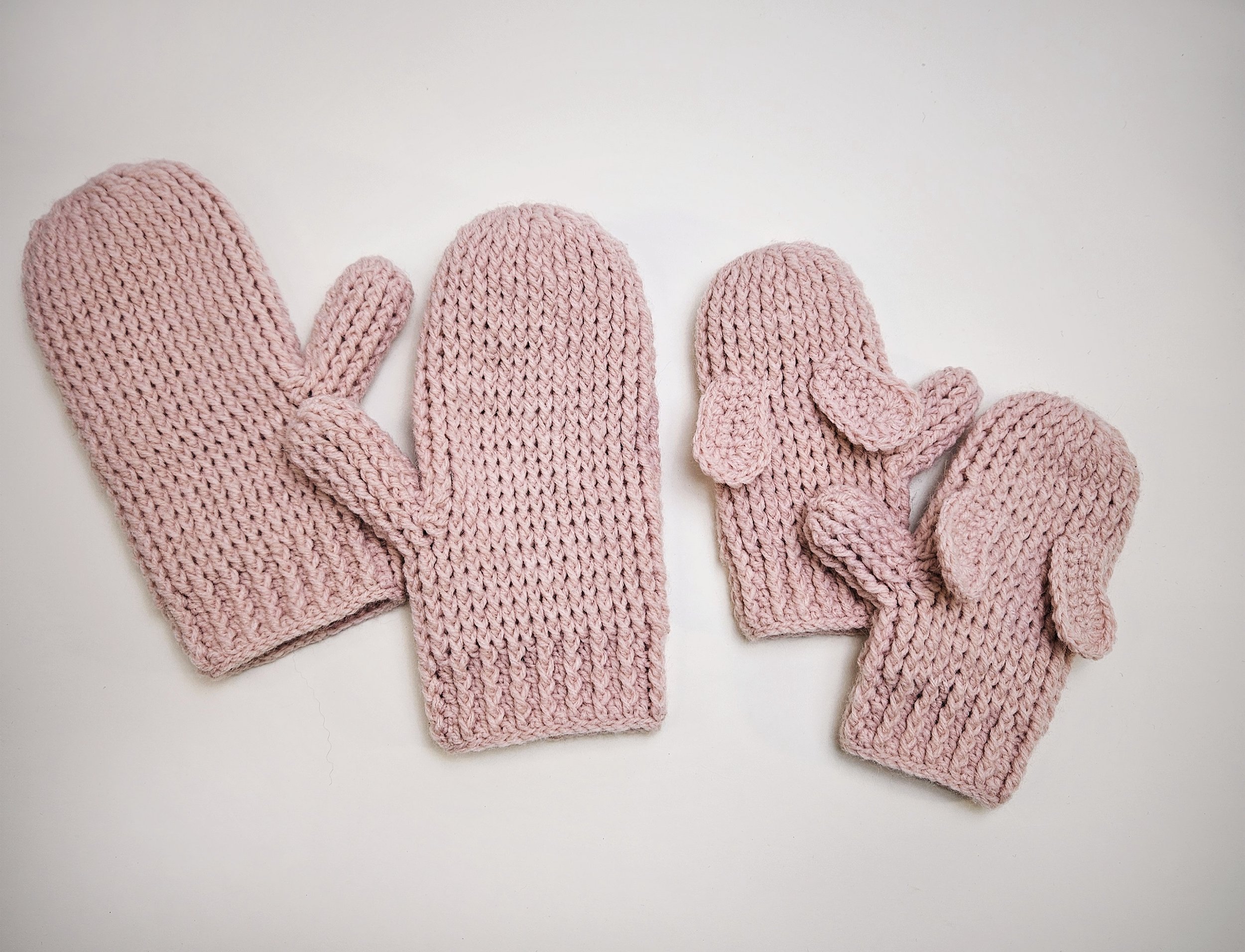 Multiple pairs of Hoppy Hands Mittens in various sizes arranged in a row to showcase the size range.
