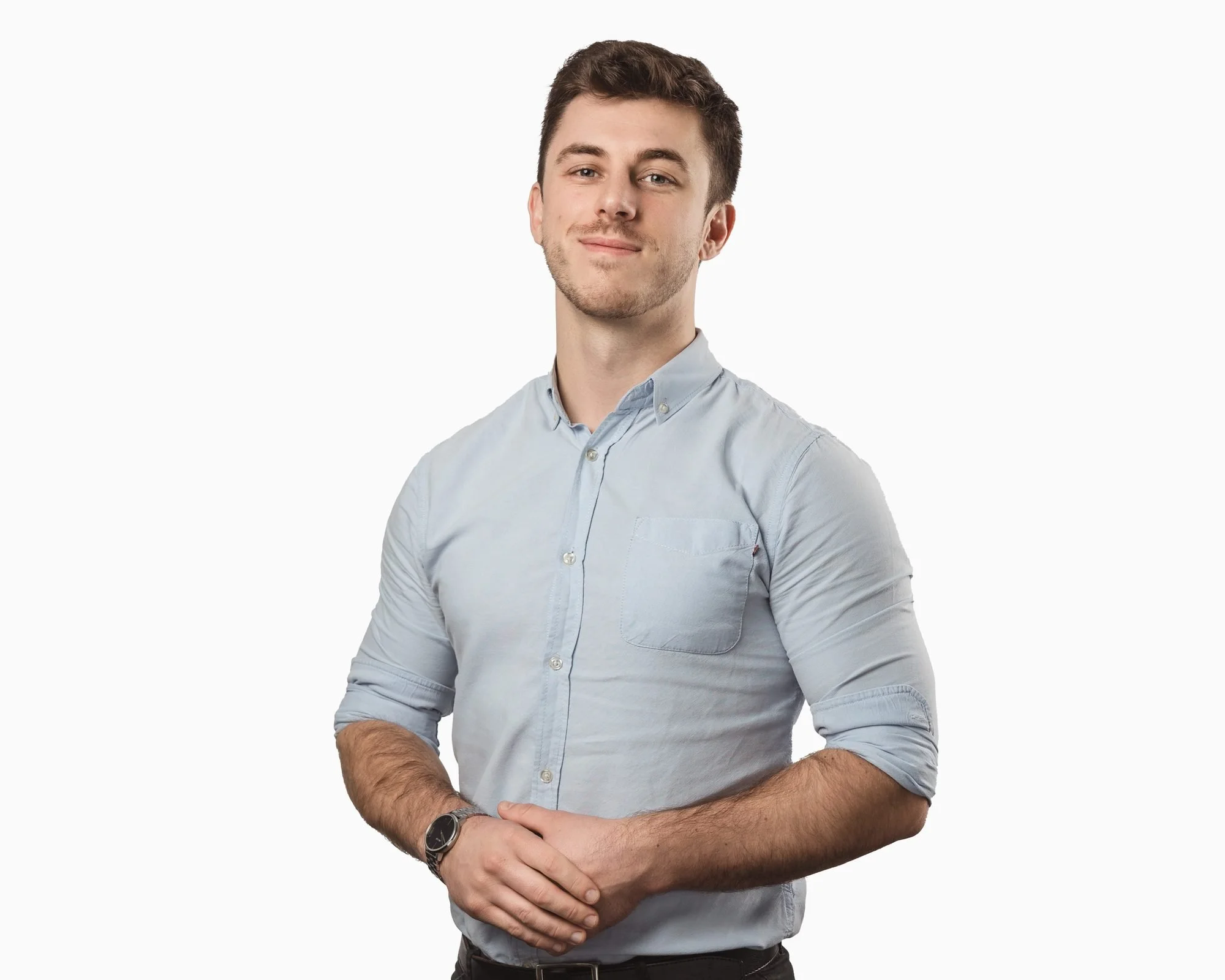Half-length corporate portrait of a man in a blue shirt with hands clasped, Wollongong
