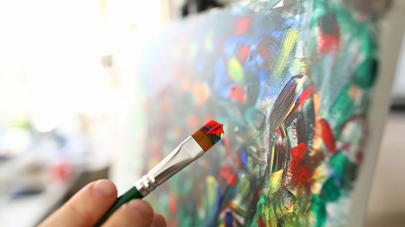 Close-up of a hand painting on a canvas.