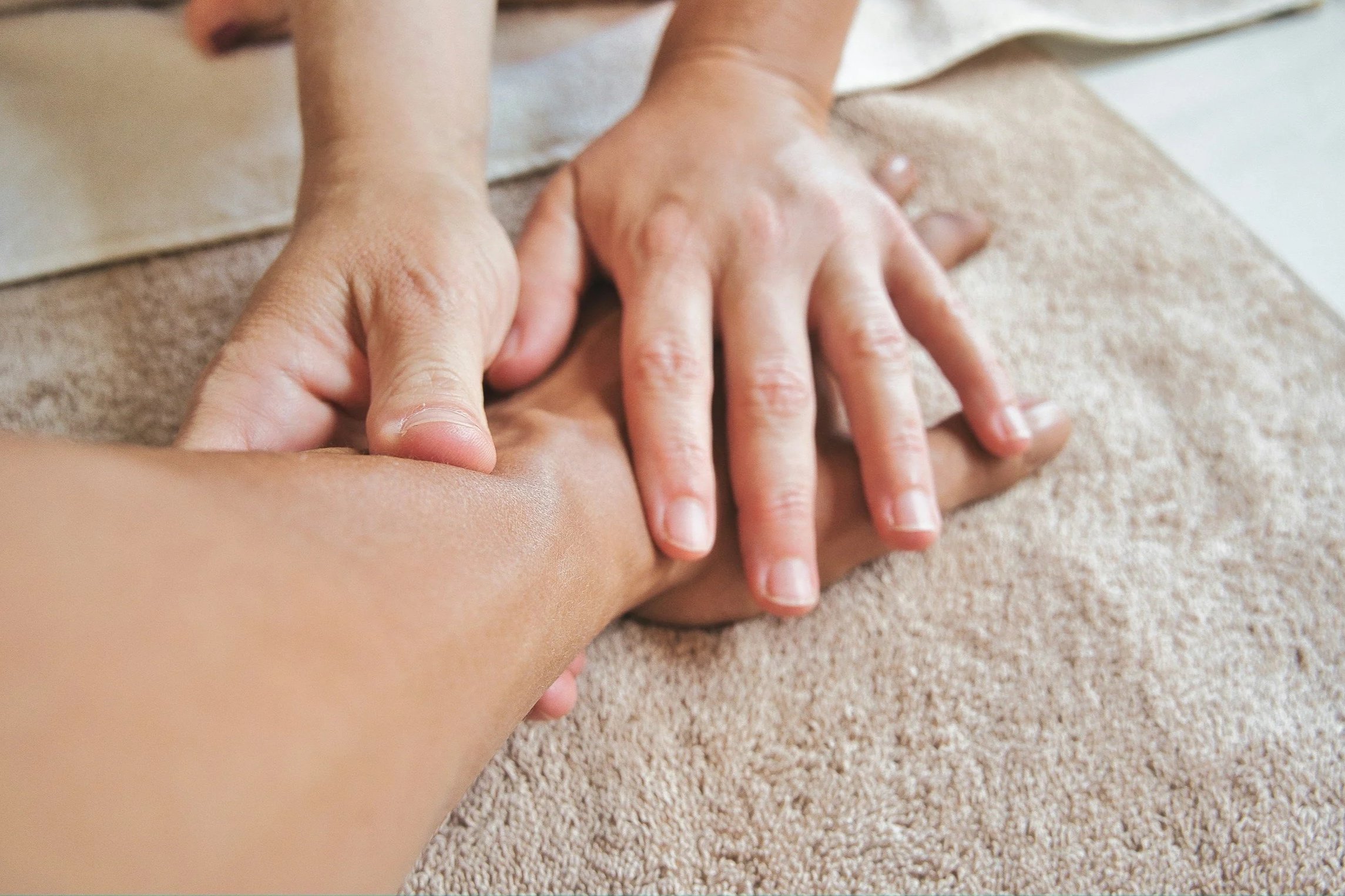 A person is on their back, receiving therapeutic touch