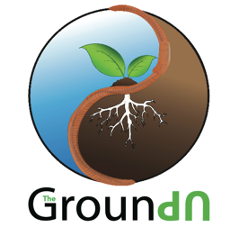 Logo saying The Ground Up with THe being small and inside of the G in Ground, and UP is upside down. There is a design of half a circle being above ground with a blue sky and plant growing and the other half is underground with soil and roots