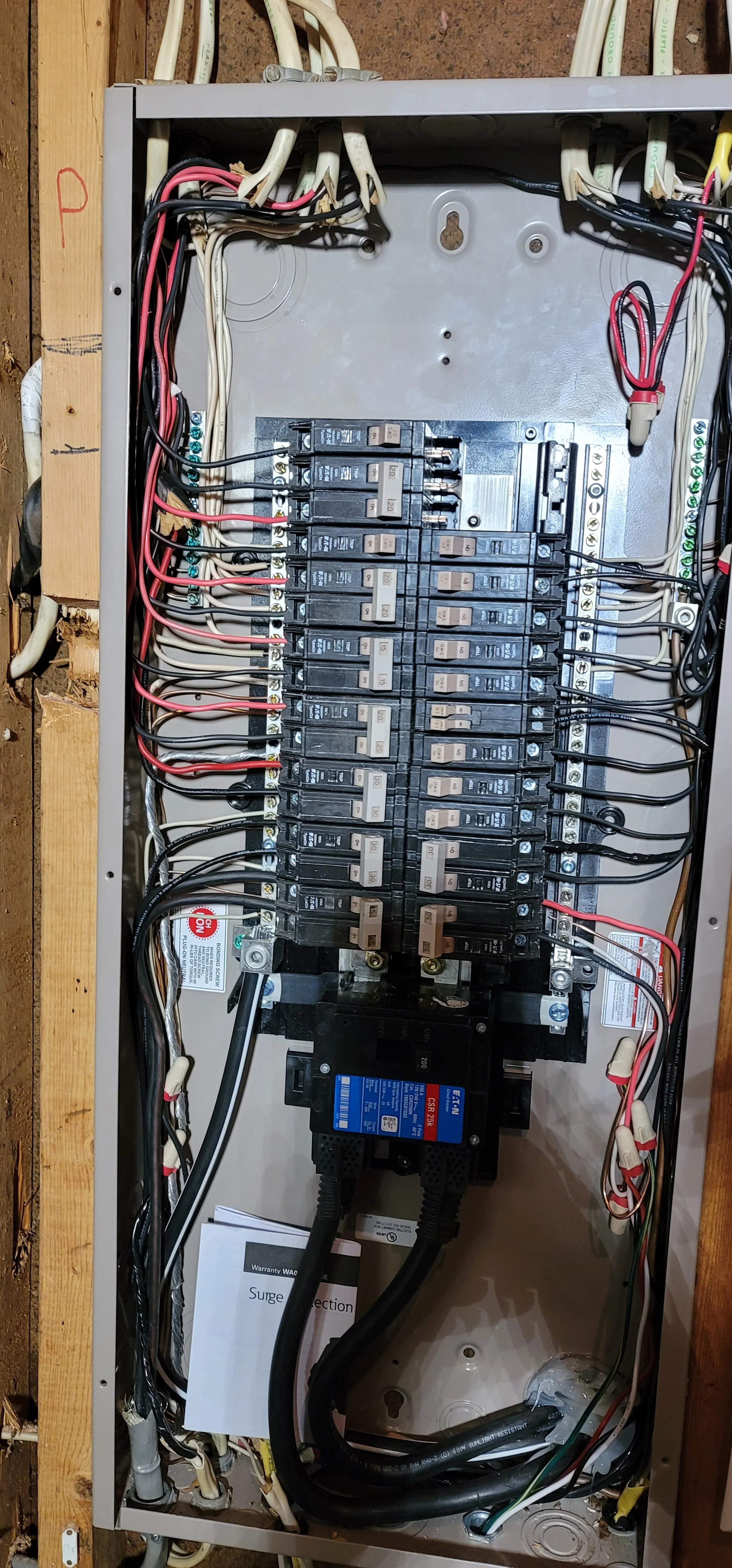 Electrical breaker box with multiple circuit breakers and wiring inside a metal panel.