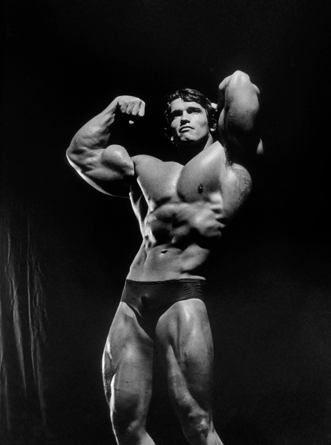 Arnold Schwarzenegger hitting a classic double-biceps pose