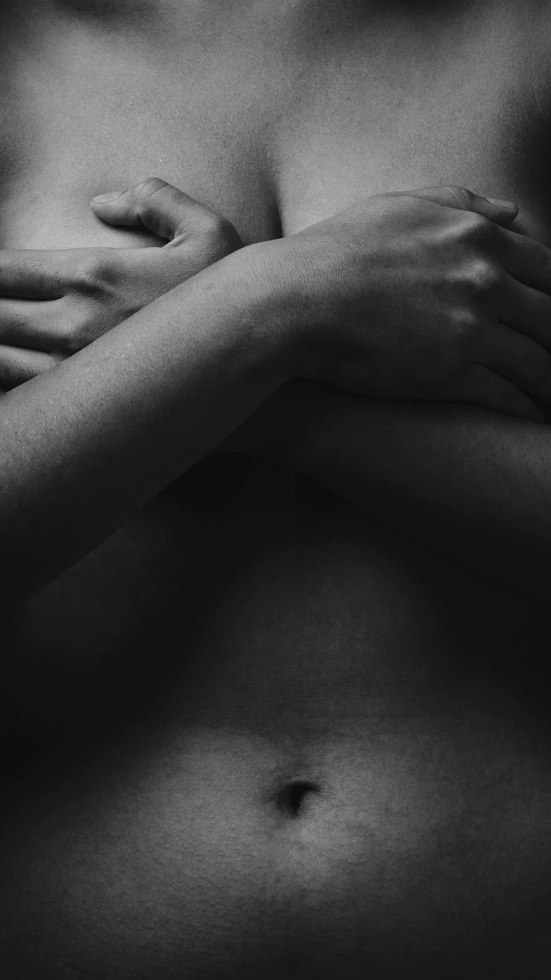 Female covering her breast with her hand.