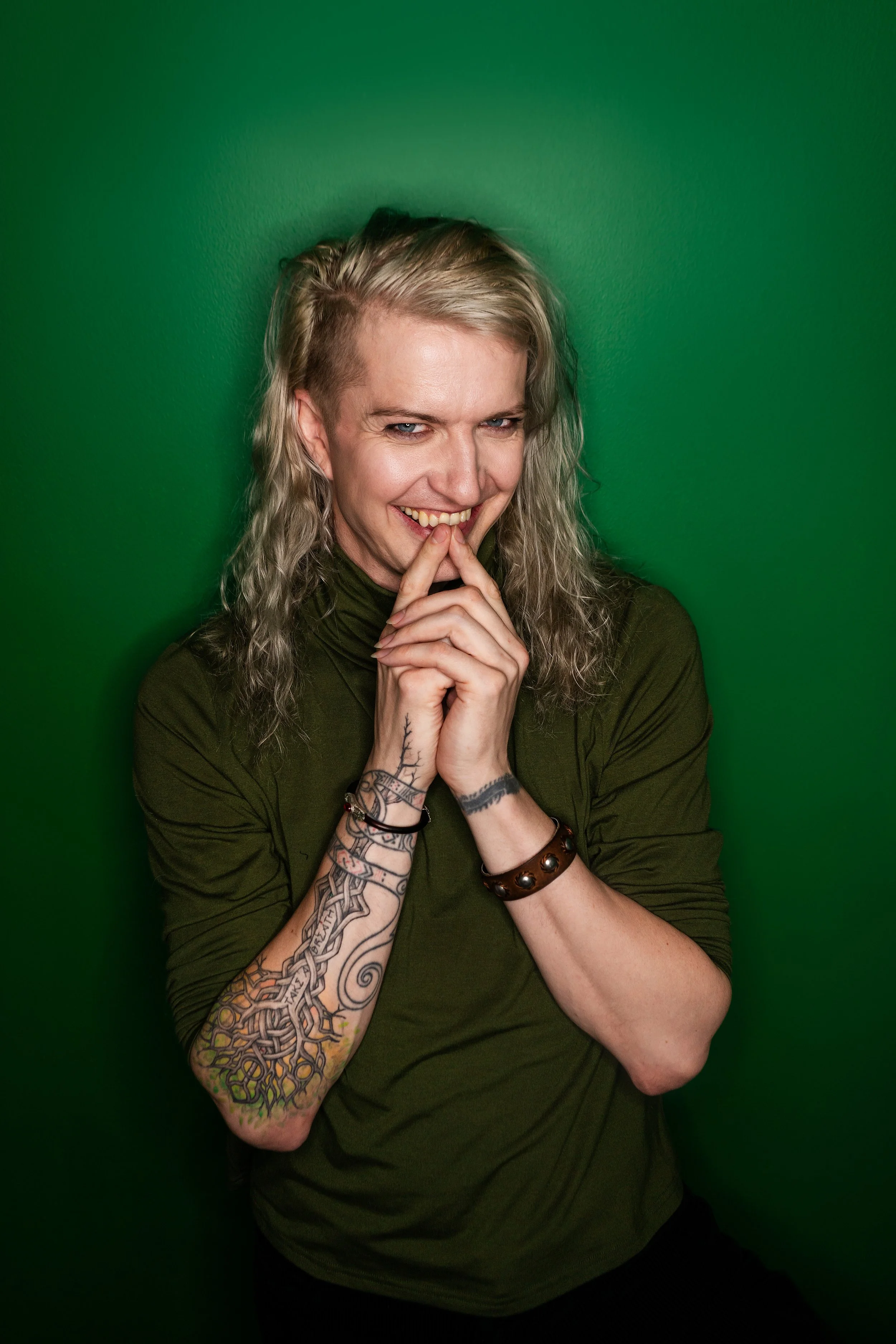 Kai Silver in a green turtleneck smiling