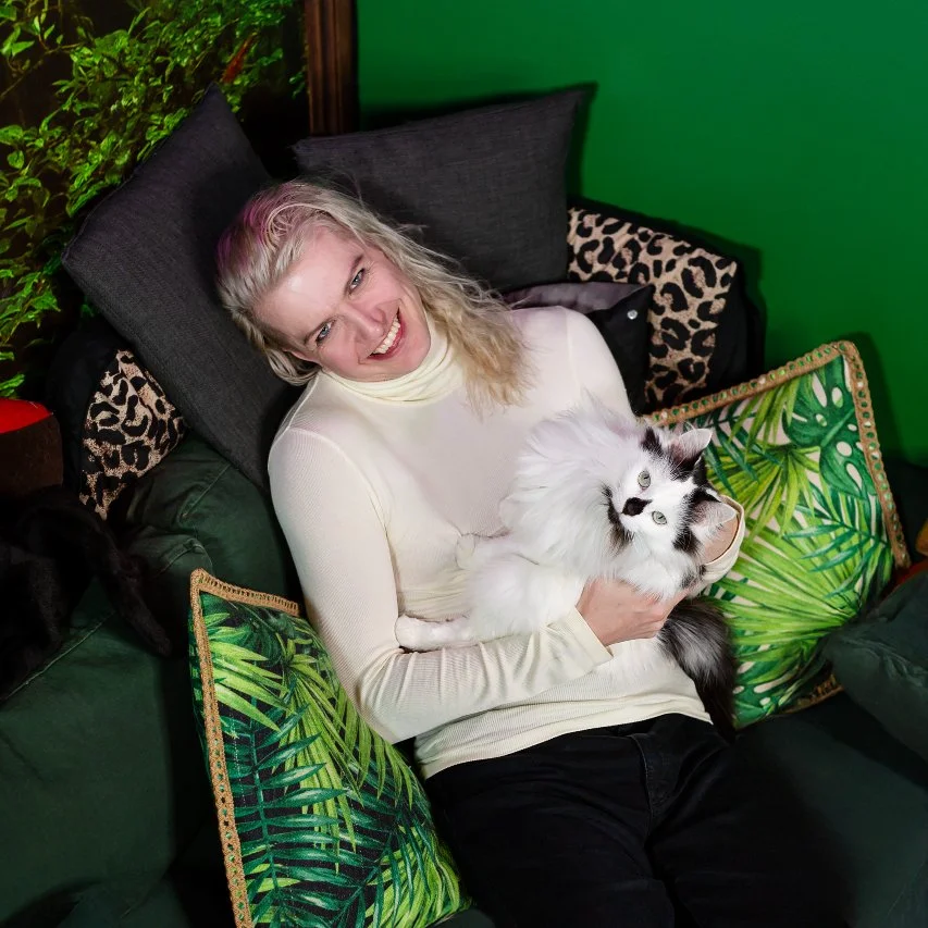 Male escort melbourns Kai Silver sitting on the couch with his cat