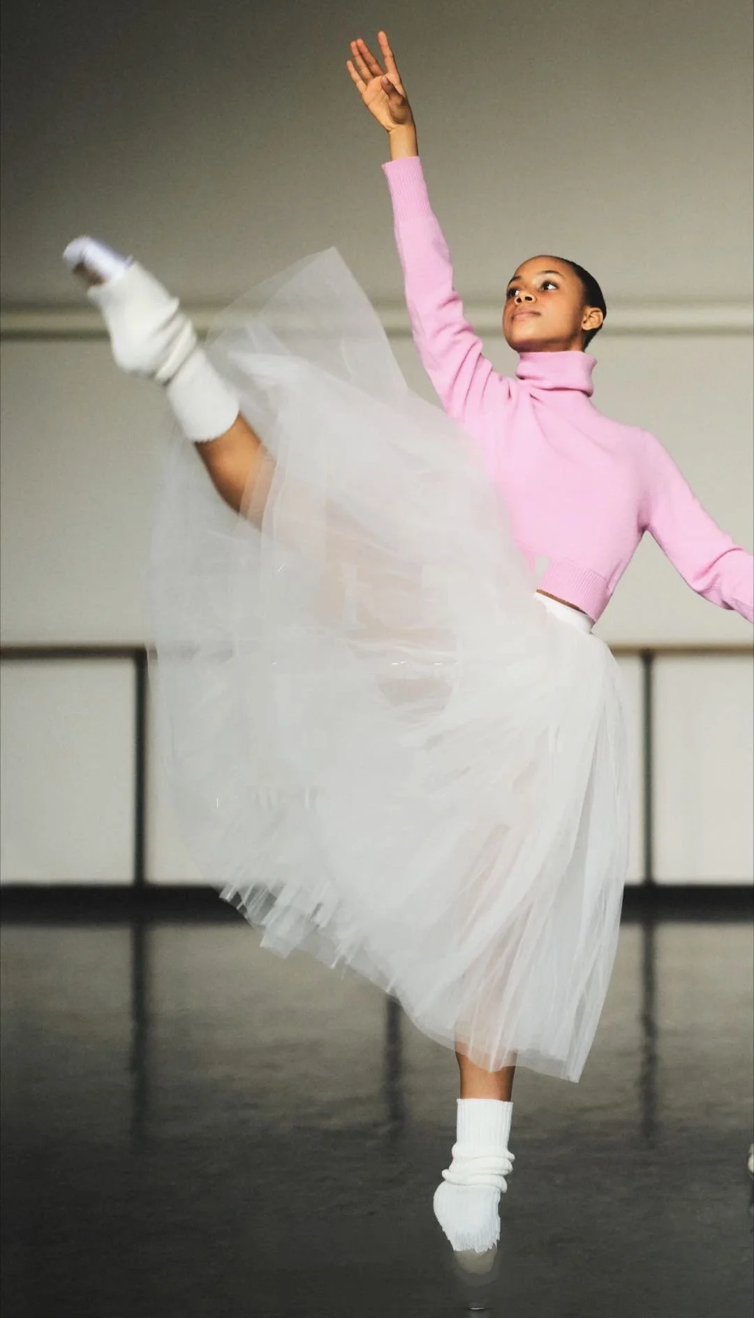Ballet dancer in a pink sweater and white tutu