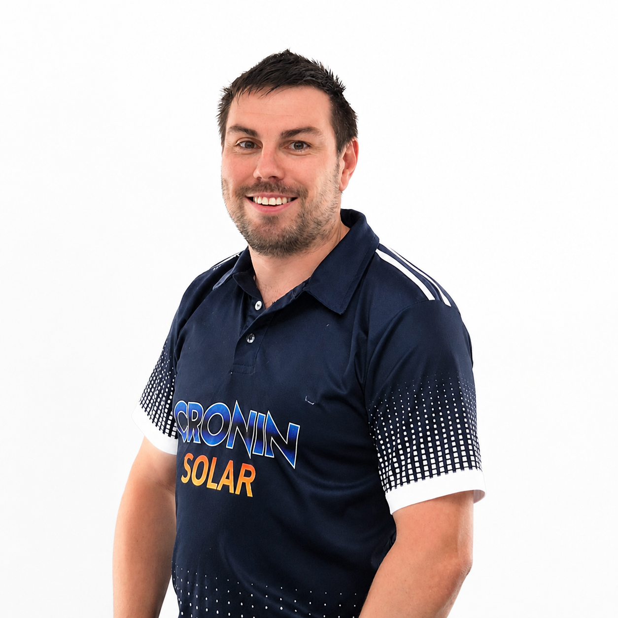 A smiling man with dark hair and a beard wearing a navy blue sports jersey with 'CRONIN SOLAR' logo, standing against a white background.