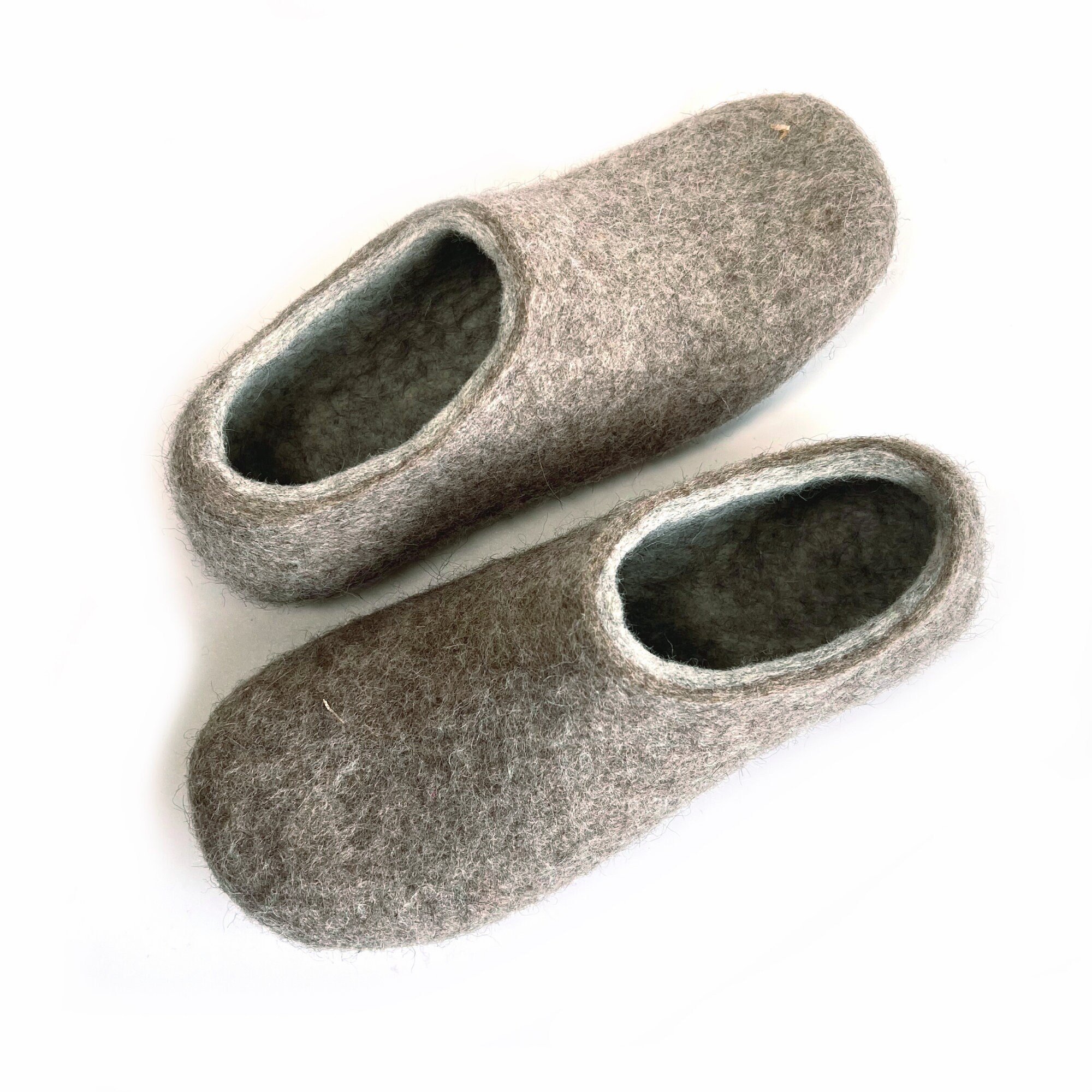 Top view of gray and beige house slippers made from natural wool. Breathable and glue-free, perfect for minimalist routines.