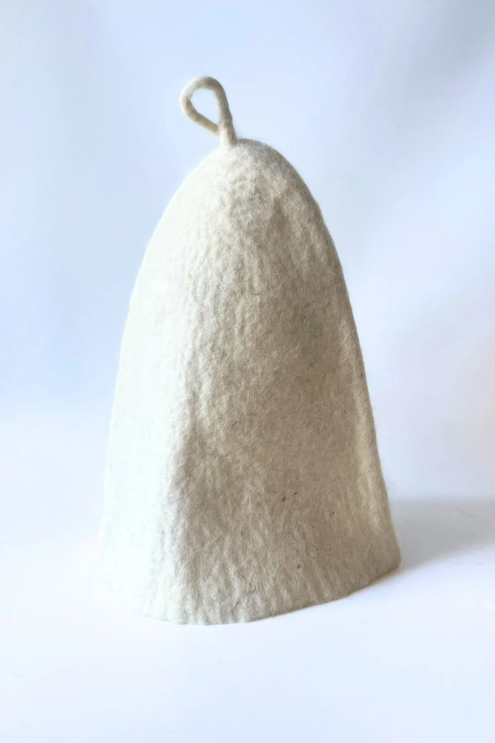 Undyed wool sauna hat with a hanging loop, hand-sculpted by Dovile FELTFORMA