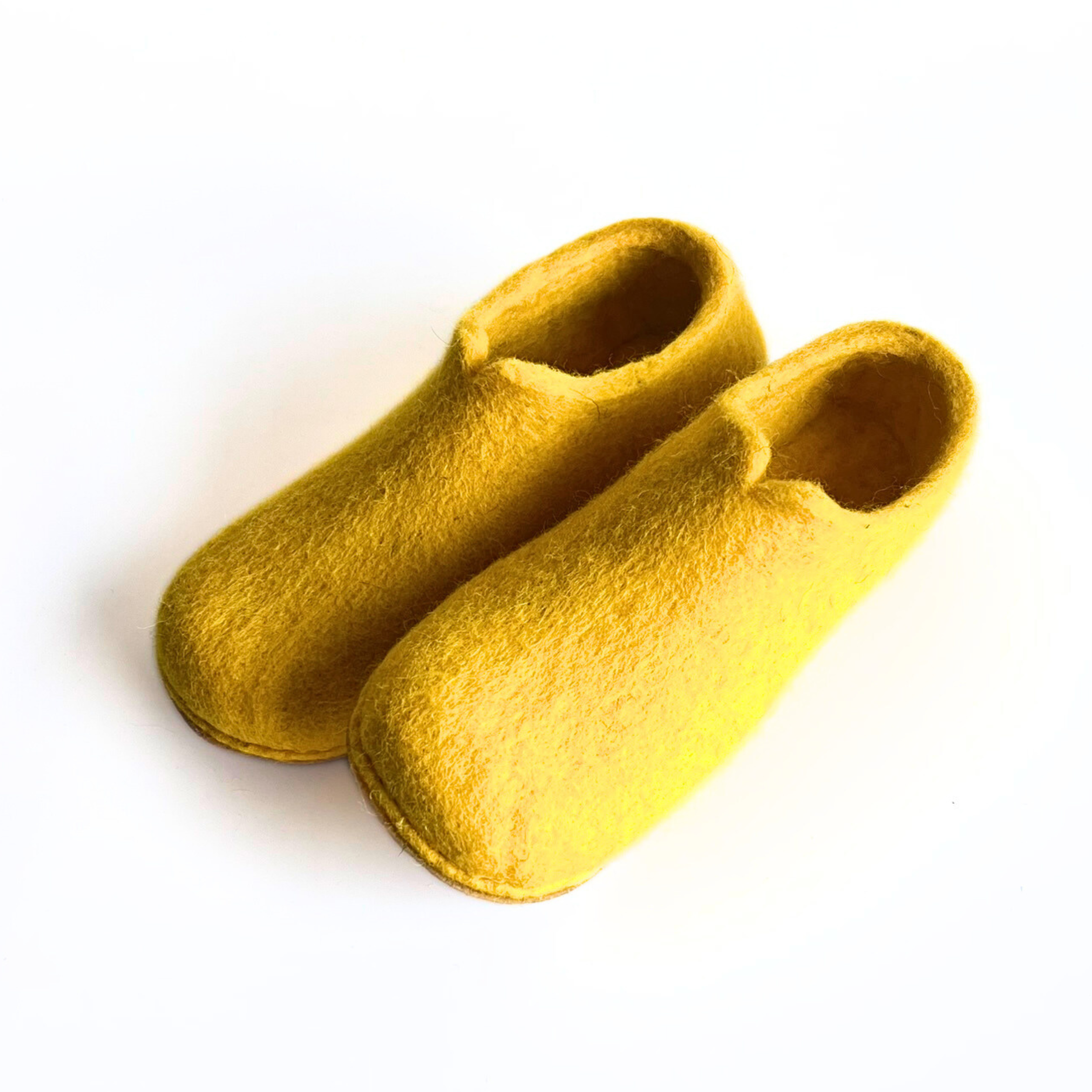 Handmade yellow felt slippers with clean form and rounded shape. These wool shoes offer breathable, barefoot support.