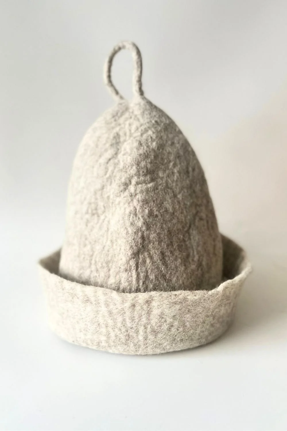 Undyed wool sauna hat with a built-in hanging loop — easy to bring to a studio, club, or hotel spa, and just as easy to hang and grab between rounds at home. Made to order at Feltforma's Europe studio.