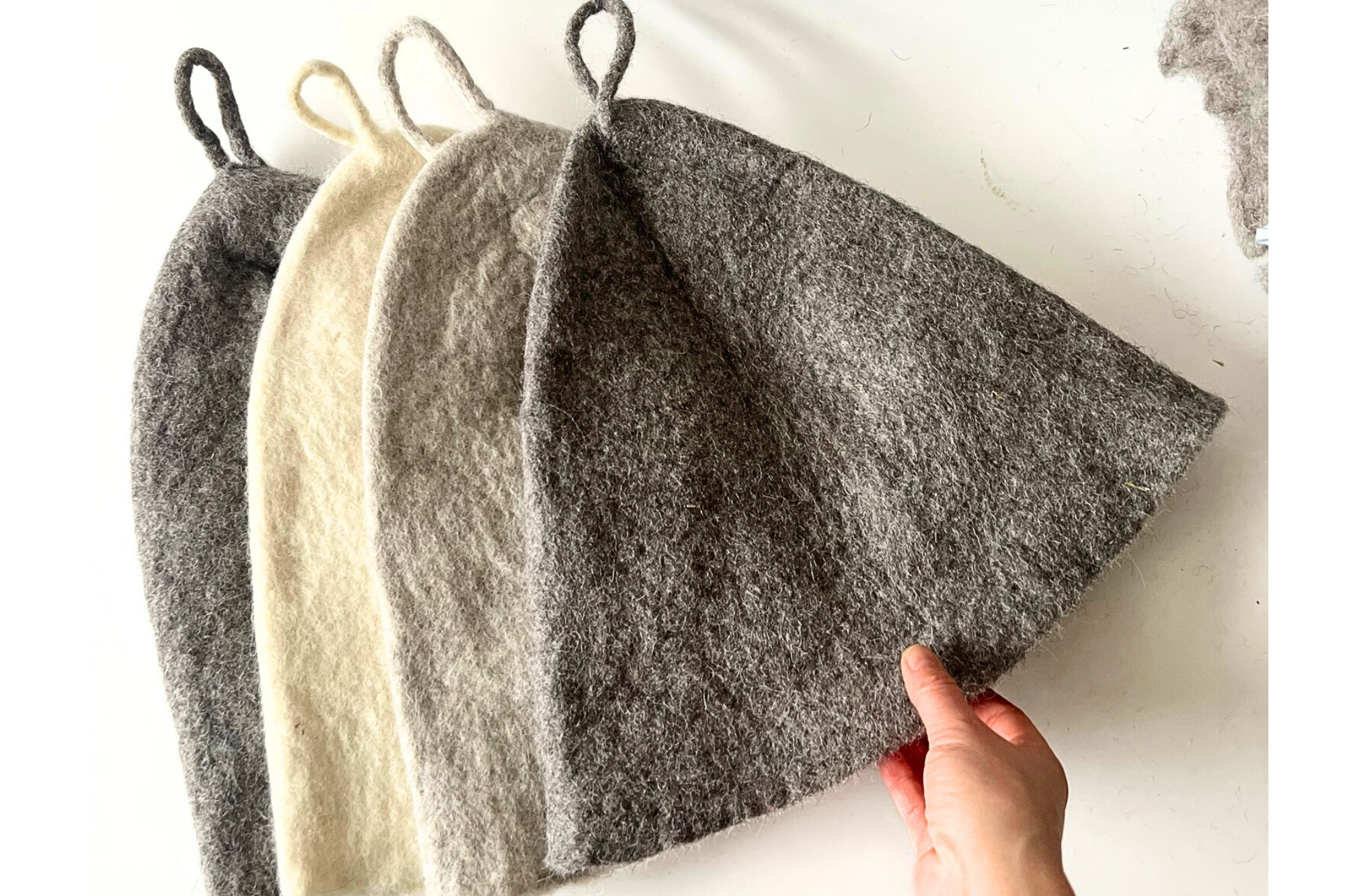 Undyed wool sauna hats designed to regulate heat and protect the head during sauna, hot plunge, and cold plunge rituals.