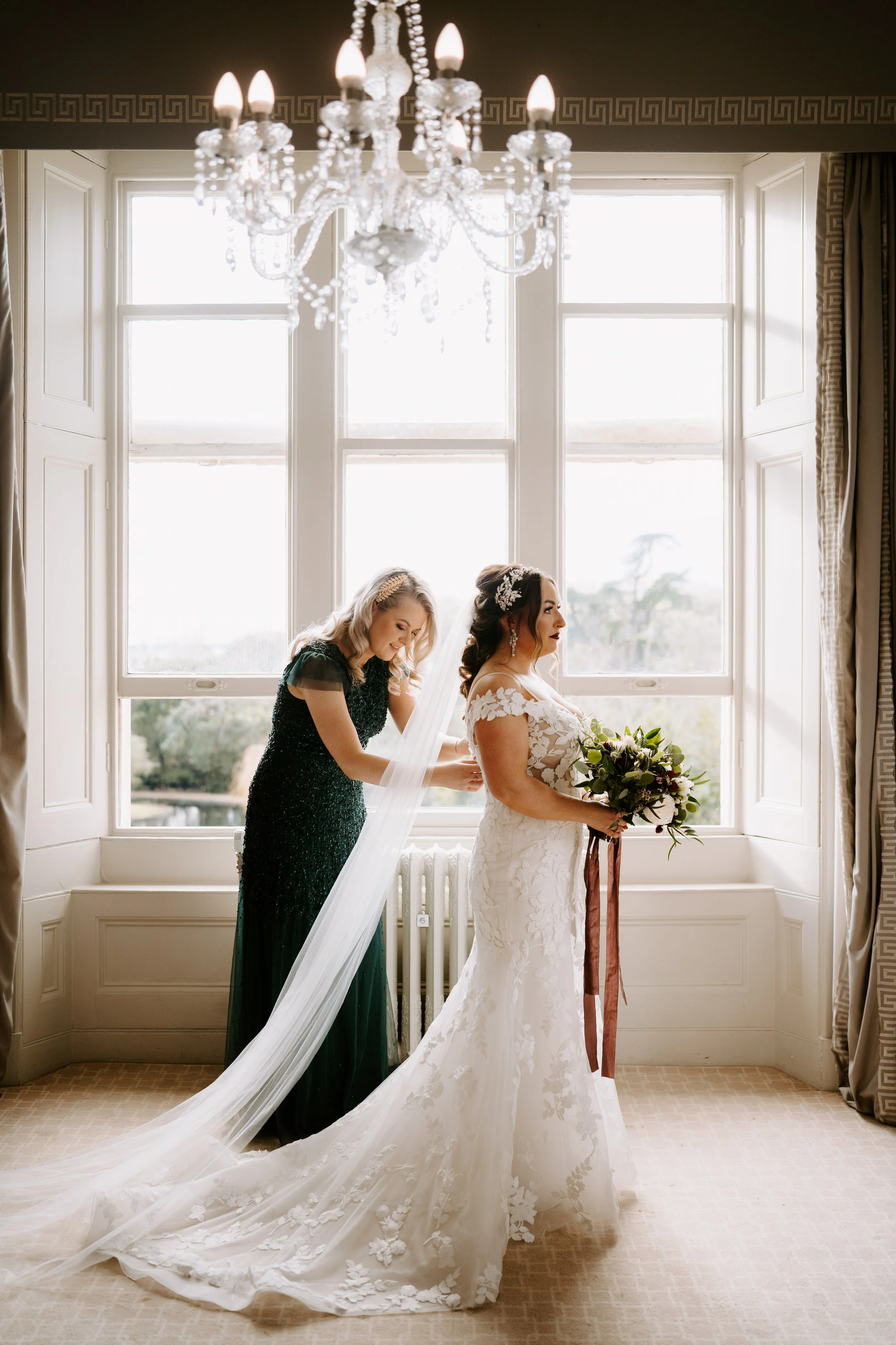 Bride Prep - Bridesmaid doing up brides dress by window