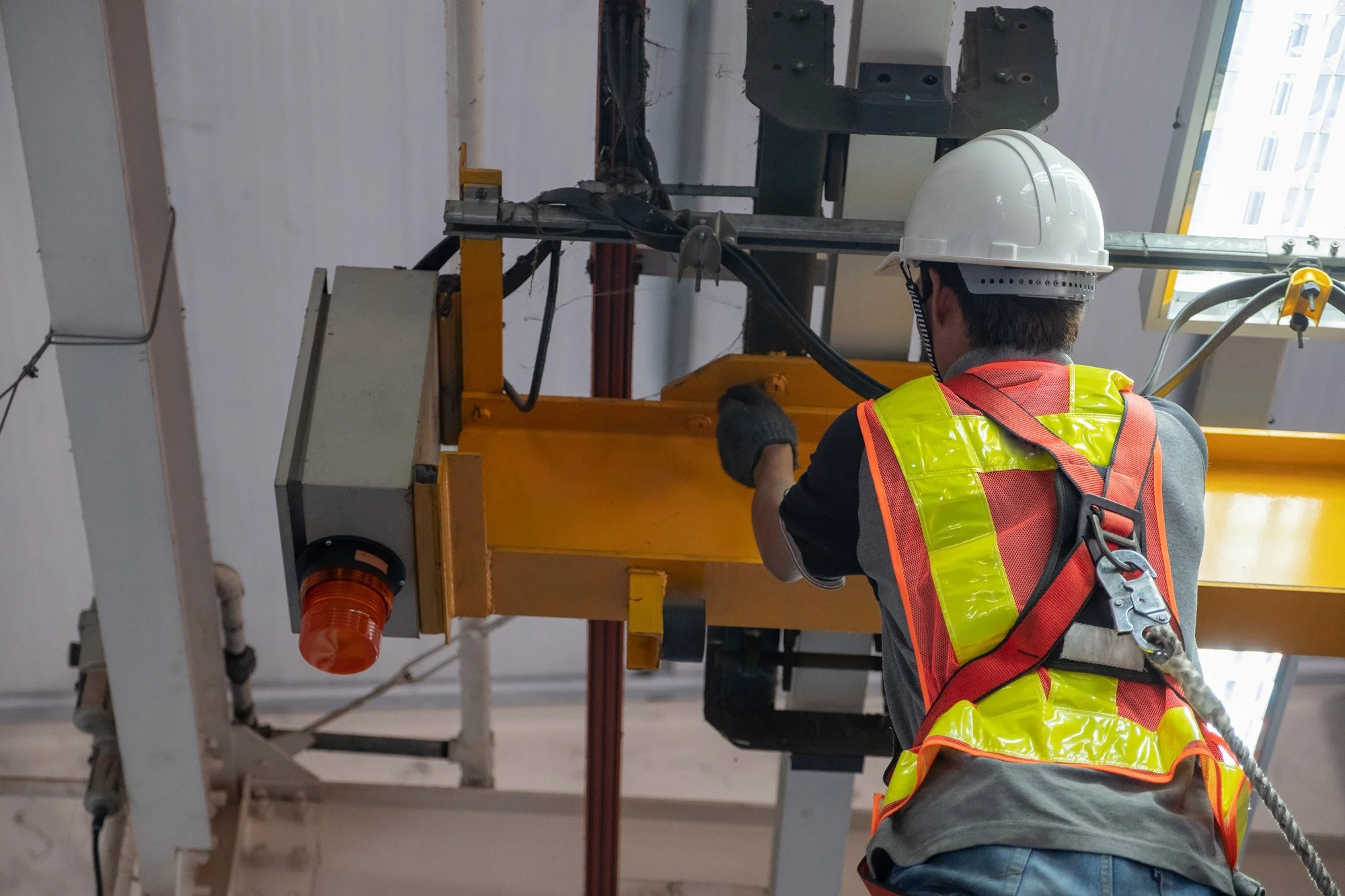 Worker in Harness Inspecting Overhead Crane.jpg